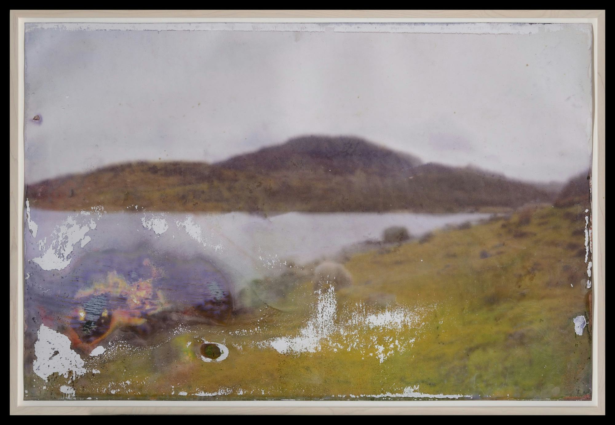A landscape depicting lake and mountains. The print is blurred on purpose. 