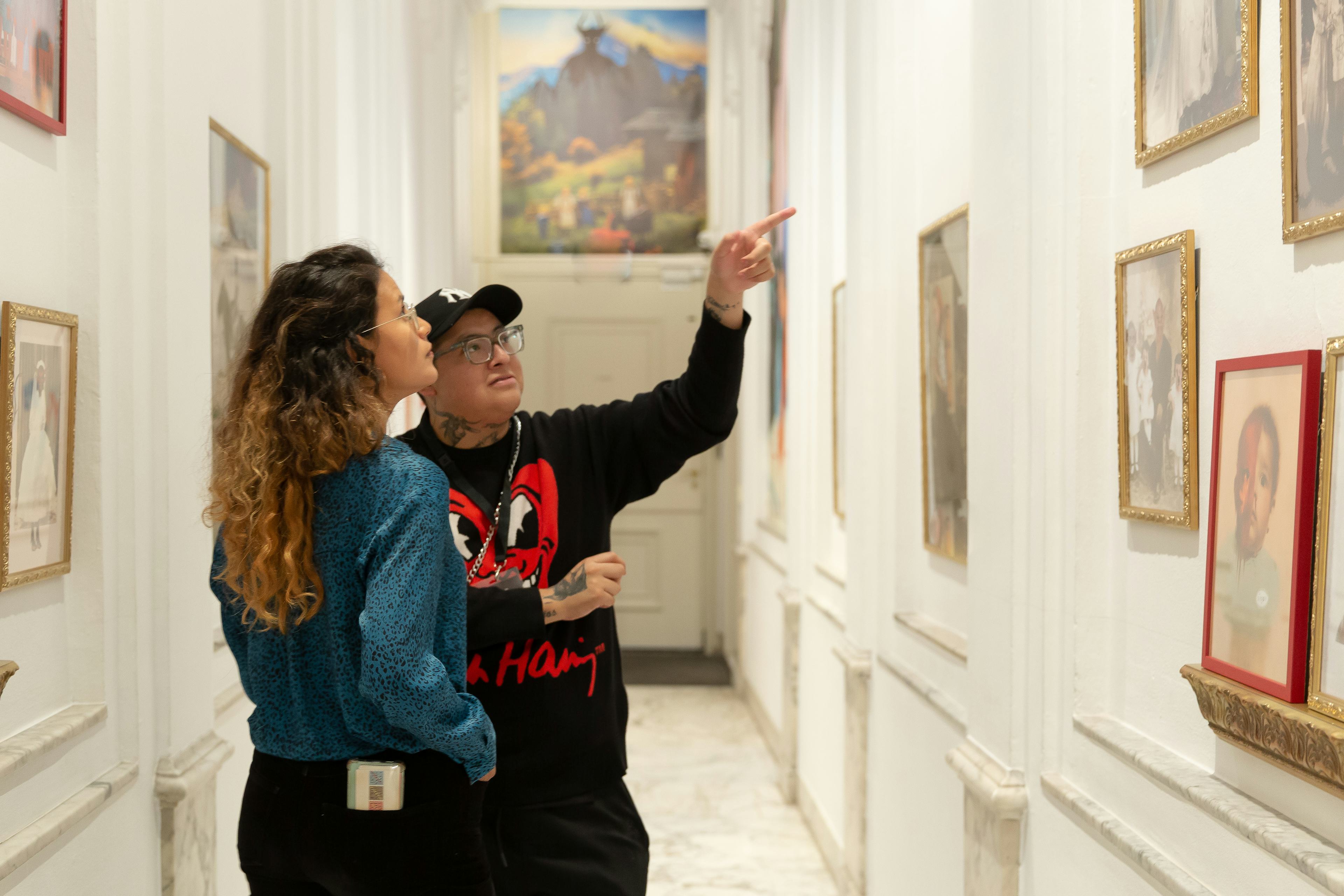 Two people looking at photos in a gallery space