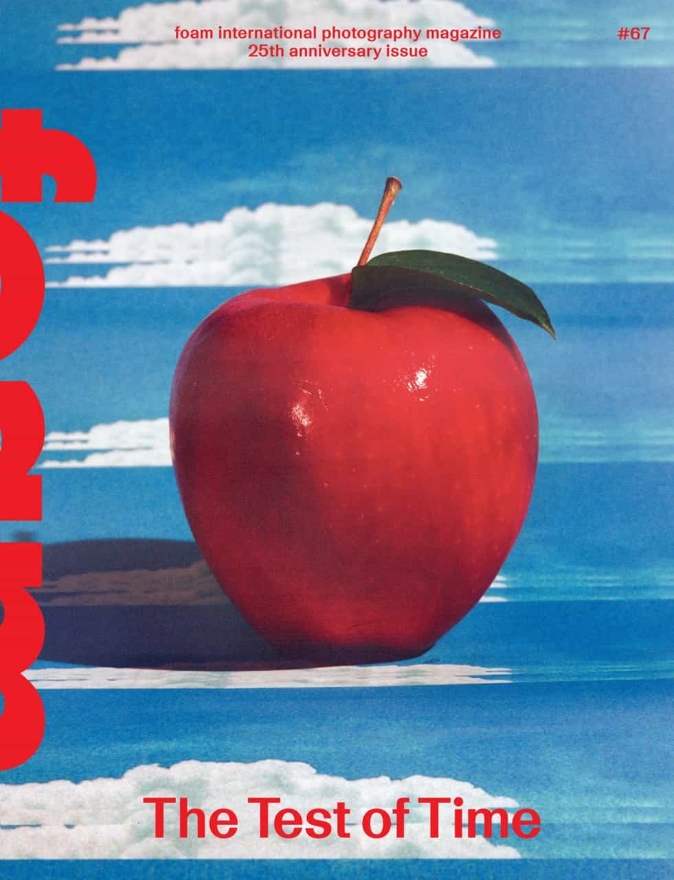 A shiny red apple with a green leaf against a blue sky with clouds, featured on the cover of a photography magazine.