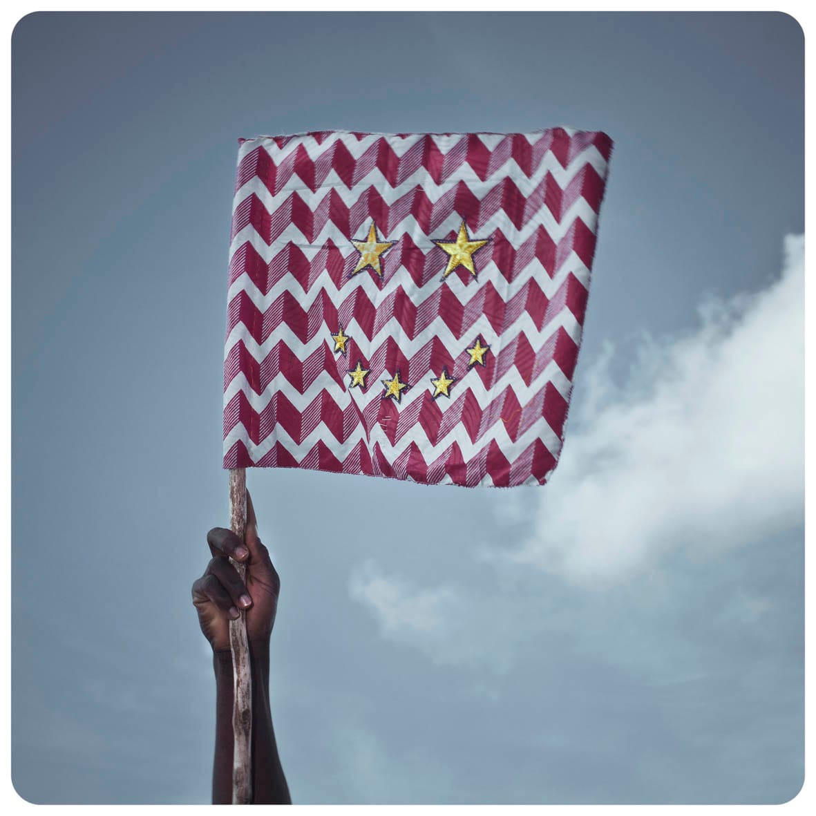 Afbeelding van een hand die een vlag vasthoudt.