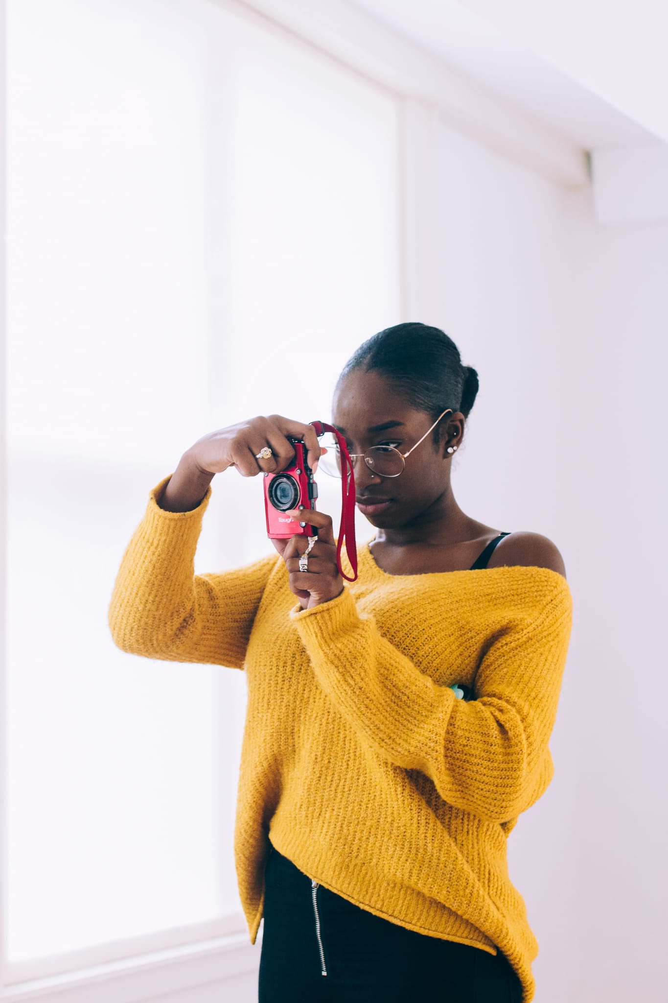 Photo of a girl in a yellow sweater taking a picture