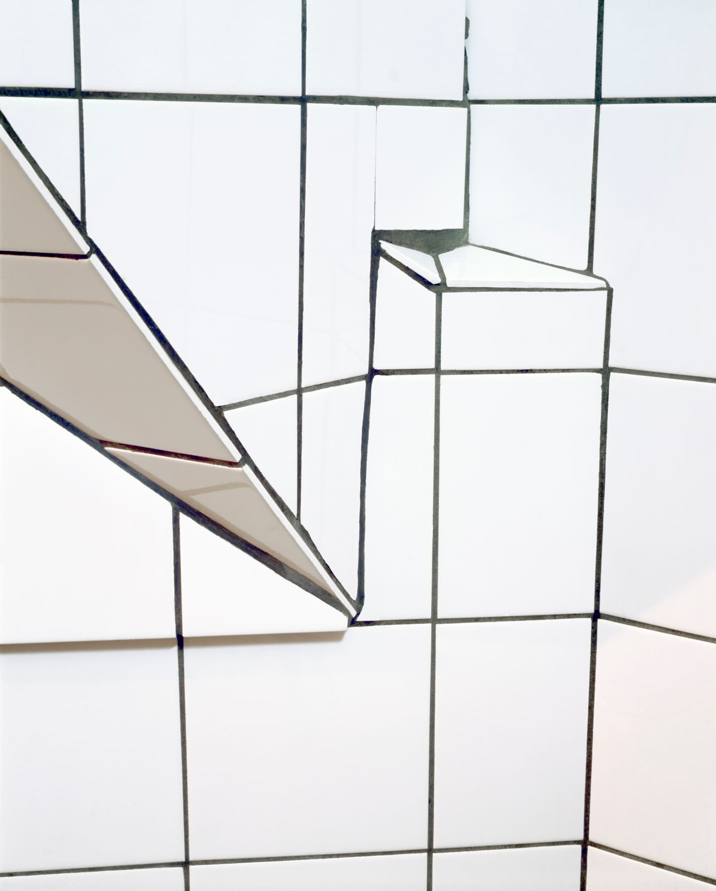 Image of a bathroom wall of white tiles. The abstraction reminds of a snow-covered landscape.