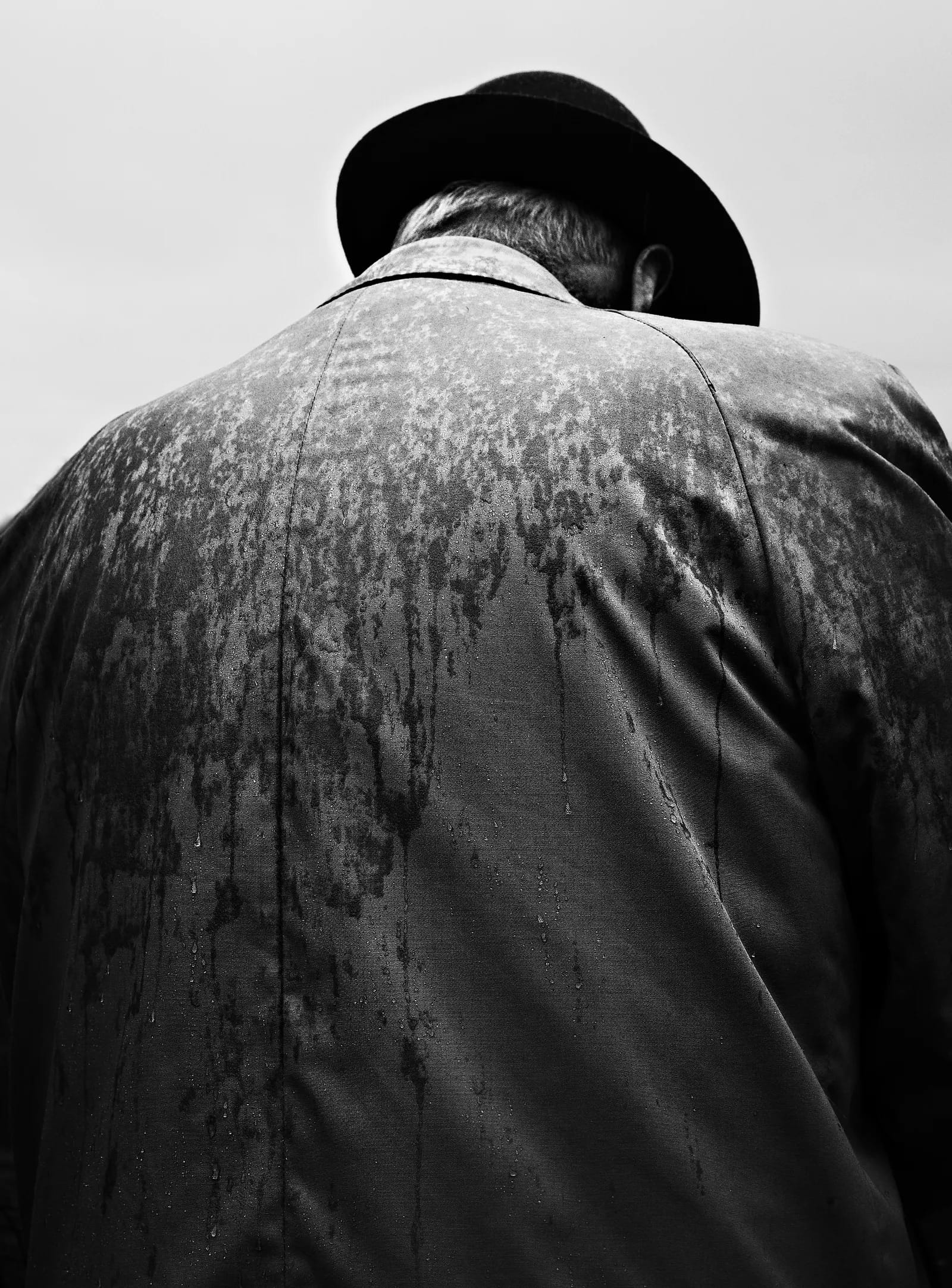 Beeld van de rug van een man in grijstinten.