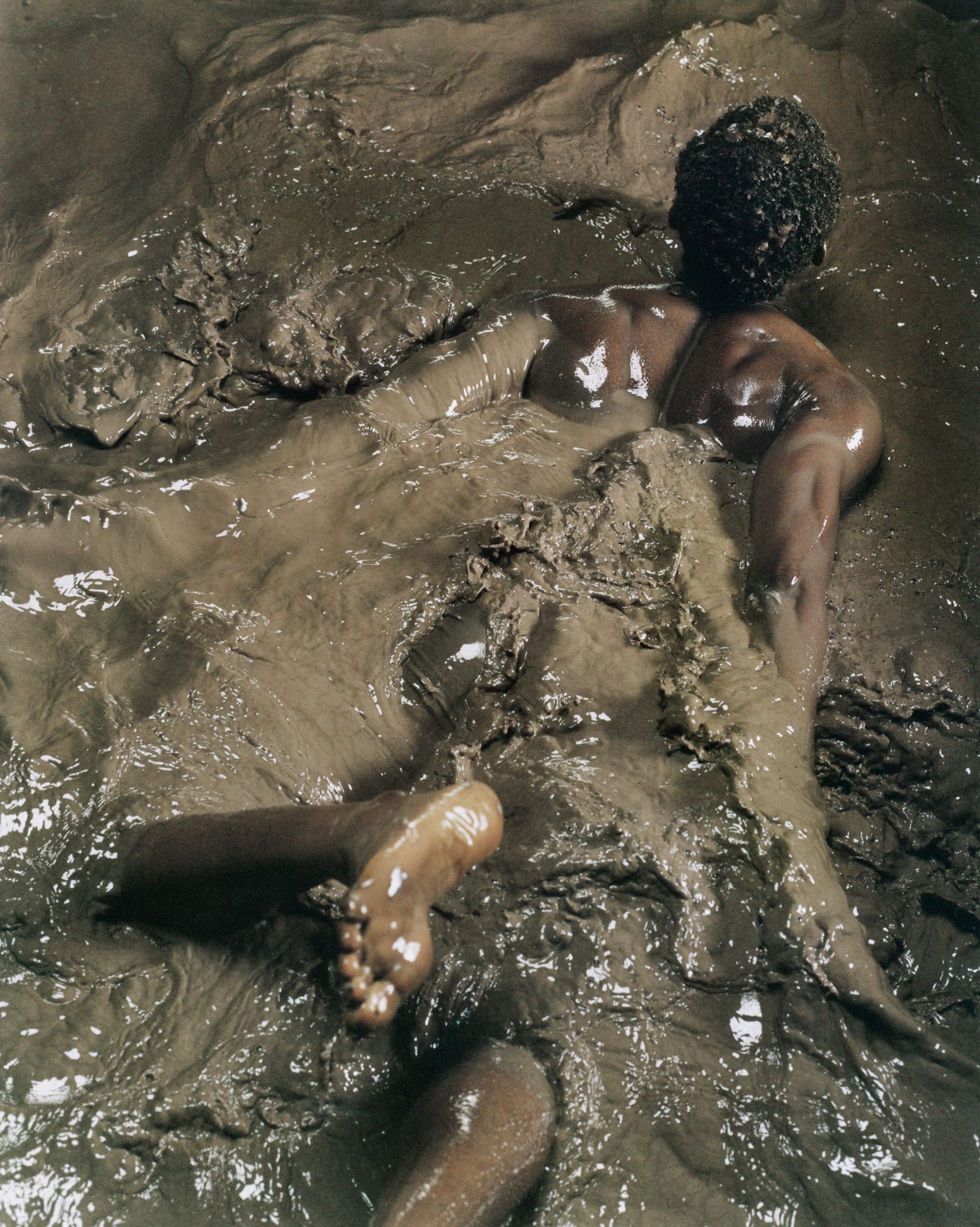man swimming in the mud