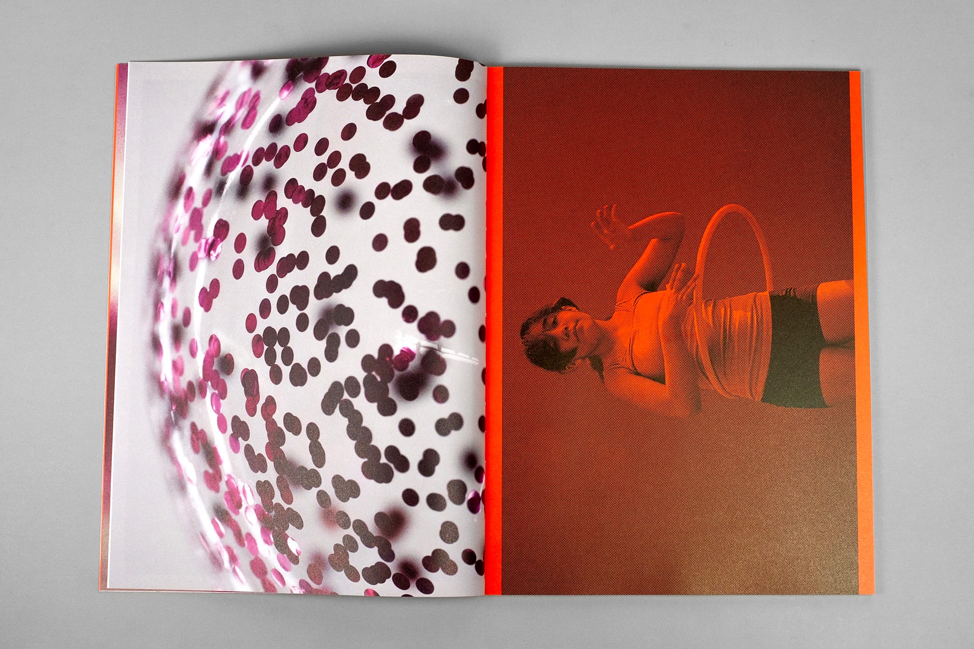 Open magazine spread: left page close-up of pink confetti dots, right page orange-tinted photo of a woman hooping in a tank top and shorts.