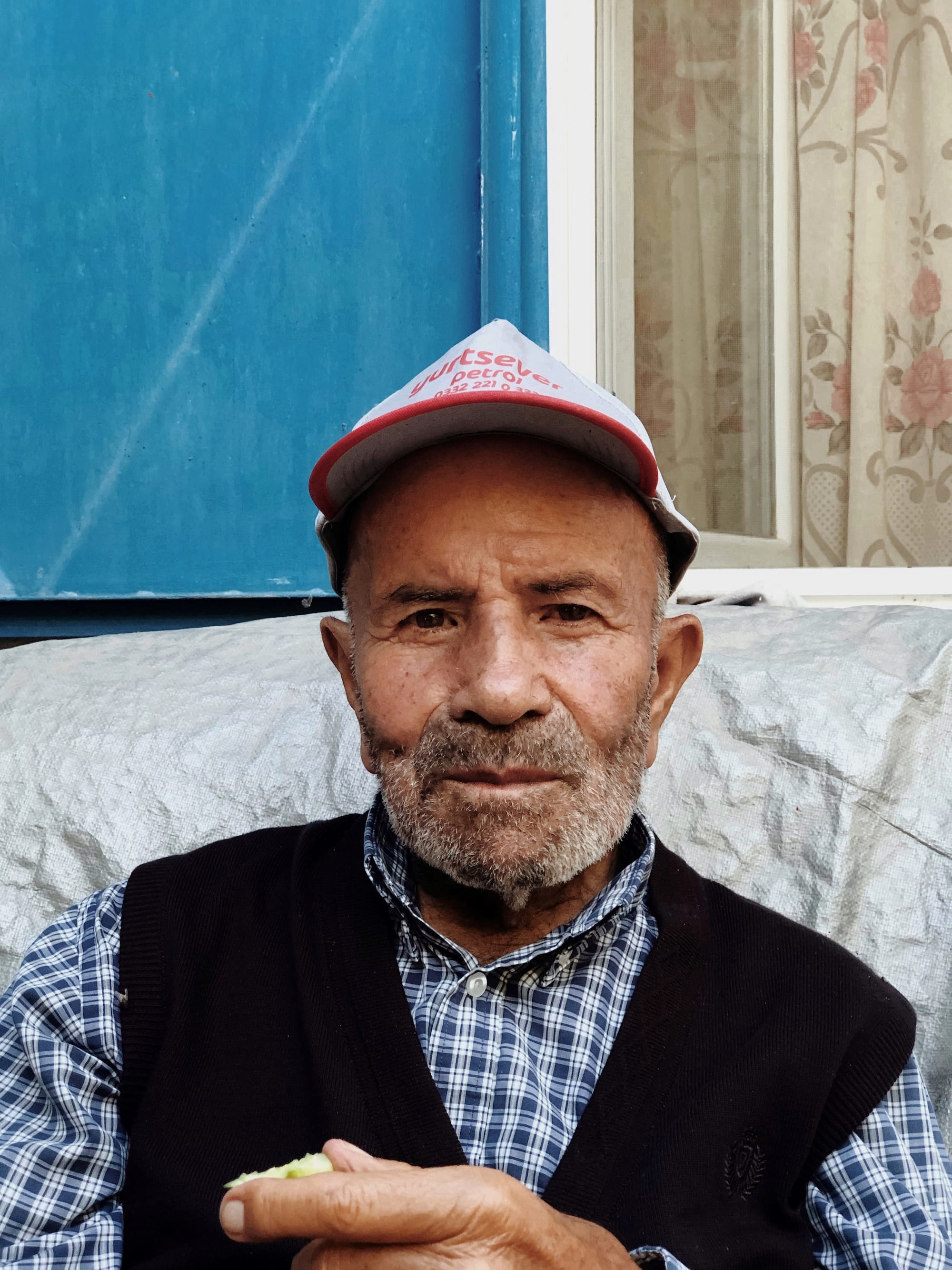 My grandfather, consuming a piece of apple in front of his home in Yeşildere. © Yasemin Demirözcan