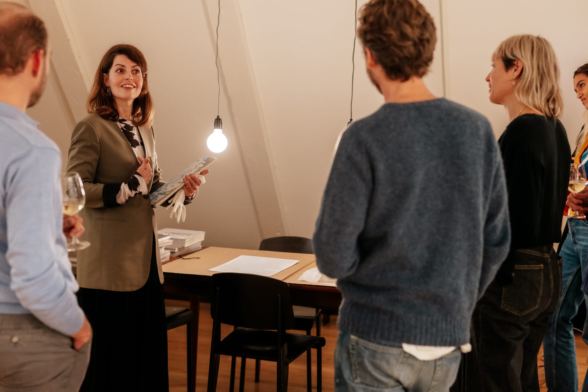 People in gallery listening to woman speaking