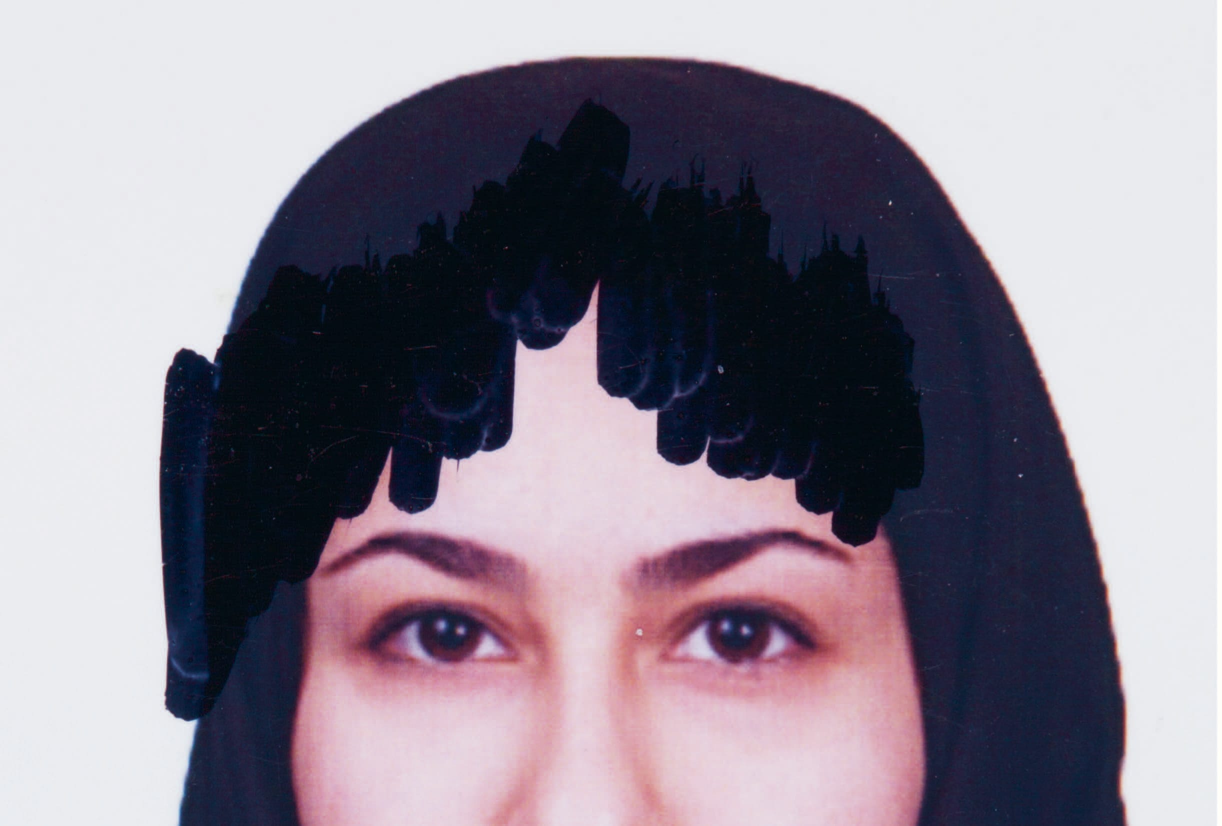A woman's face partially obscured by black scribbles, wearing a dark headscarf against a plain background.