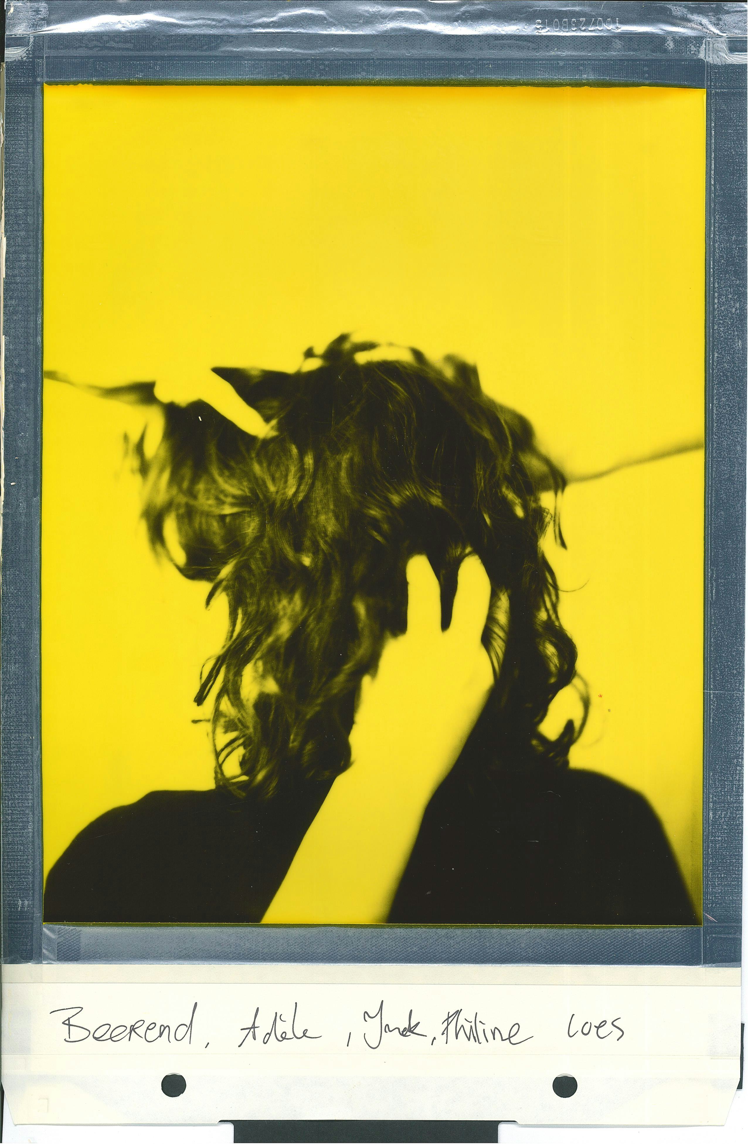 Polaroid portrait turned around woman hands touching hair yellow