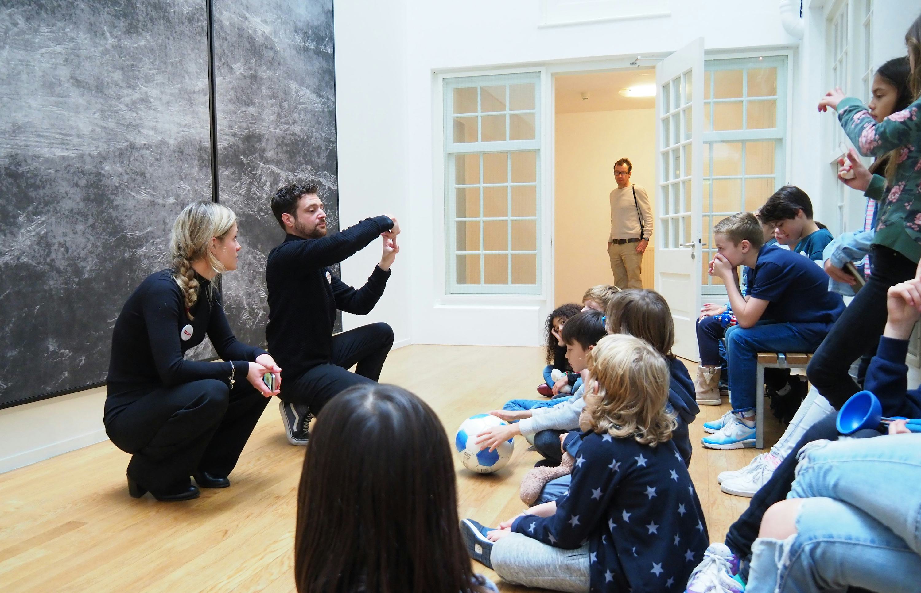 Photo of group of children listening to a museum teacher in a museum