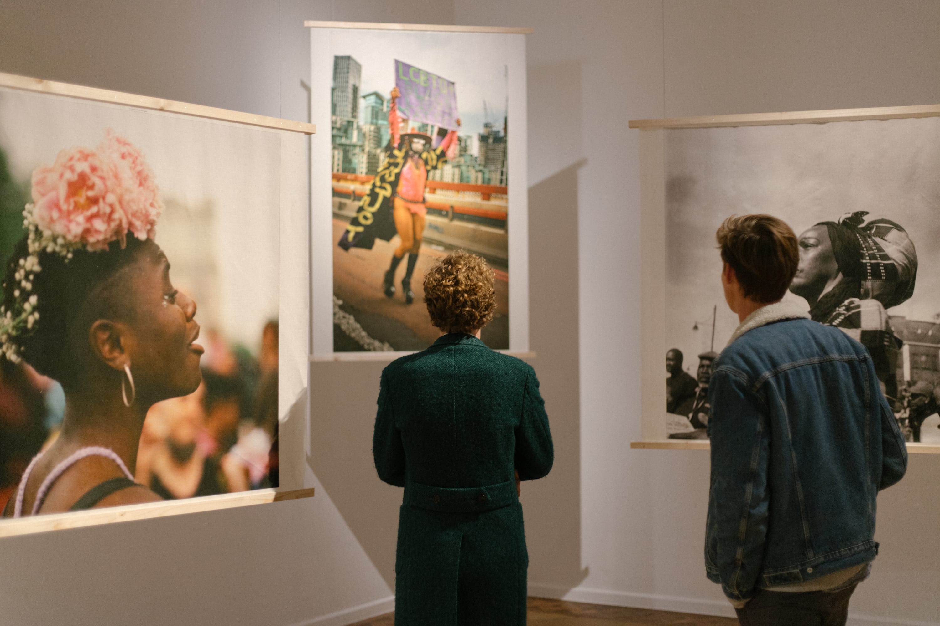 Two people from the back in front of photographs by Liz Johnson Artur at the opening at Foam Fotografiemuseum Amsterdam