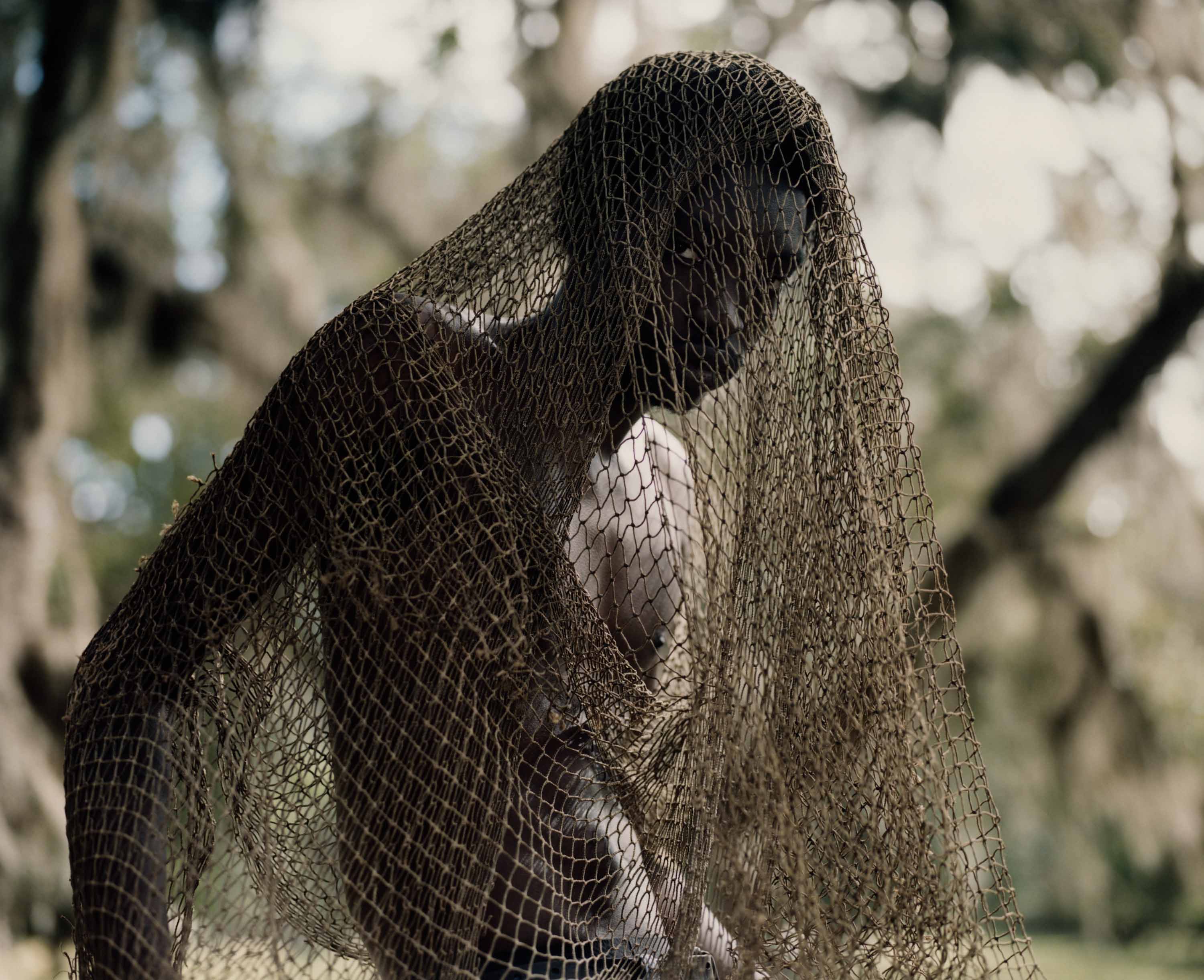 Man wrapped in fishnet in the forest