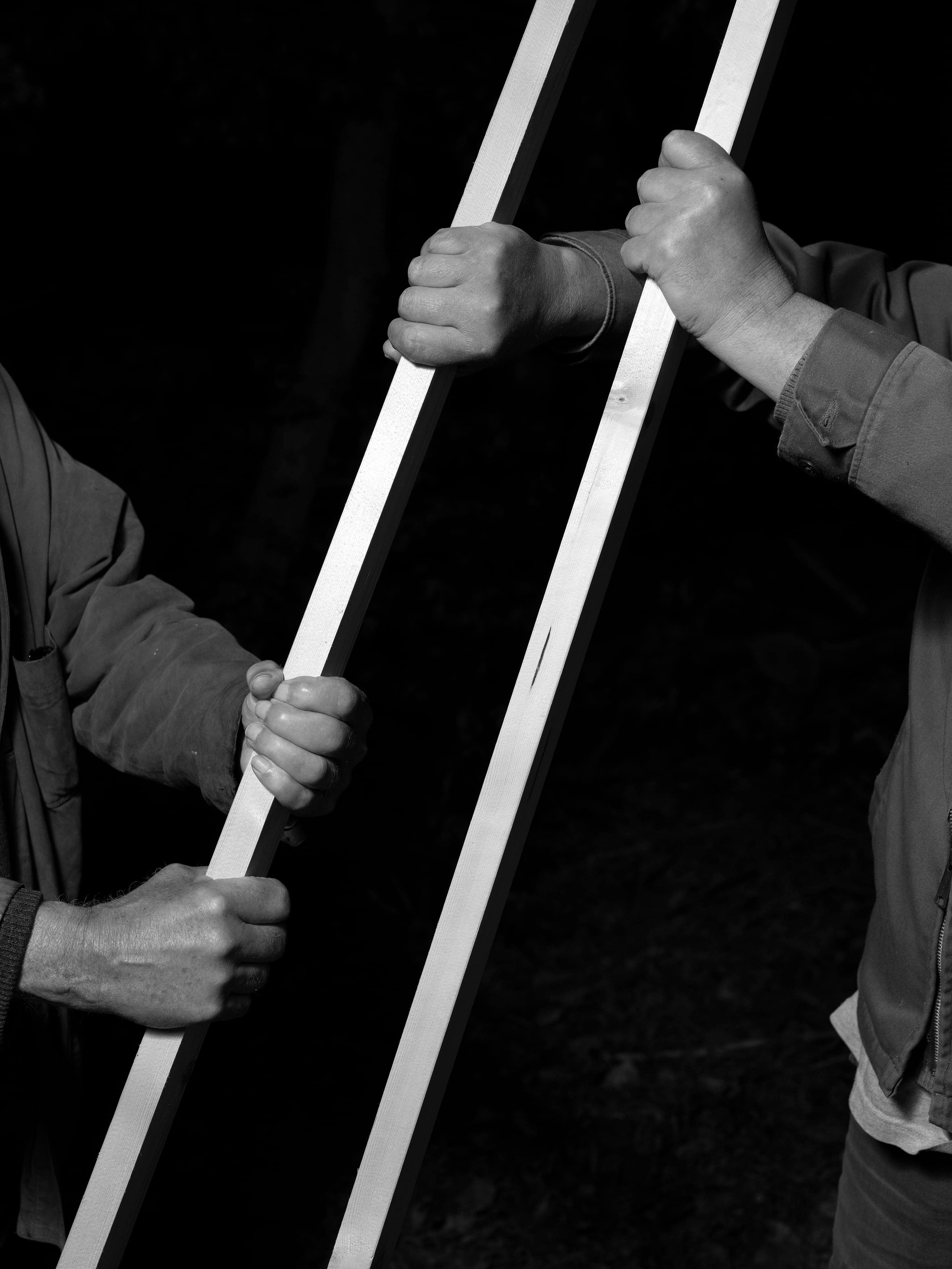 two people holding two rods in black and white