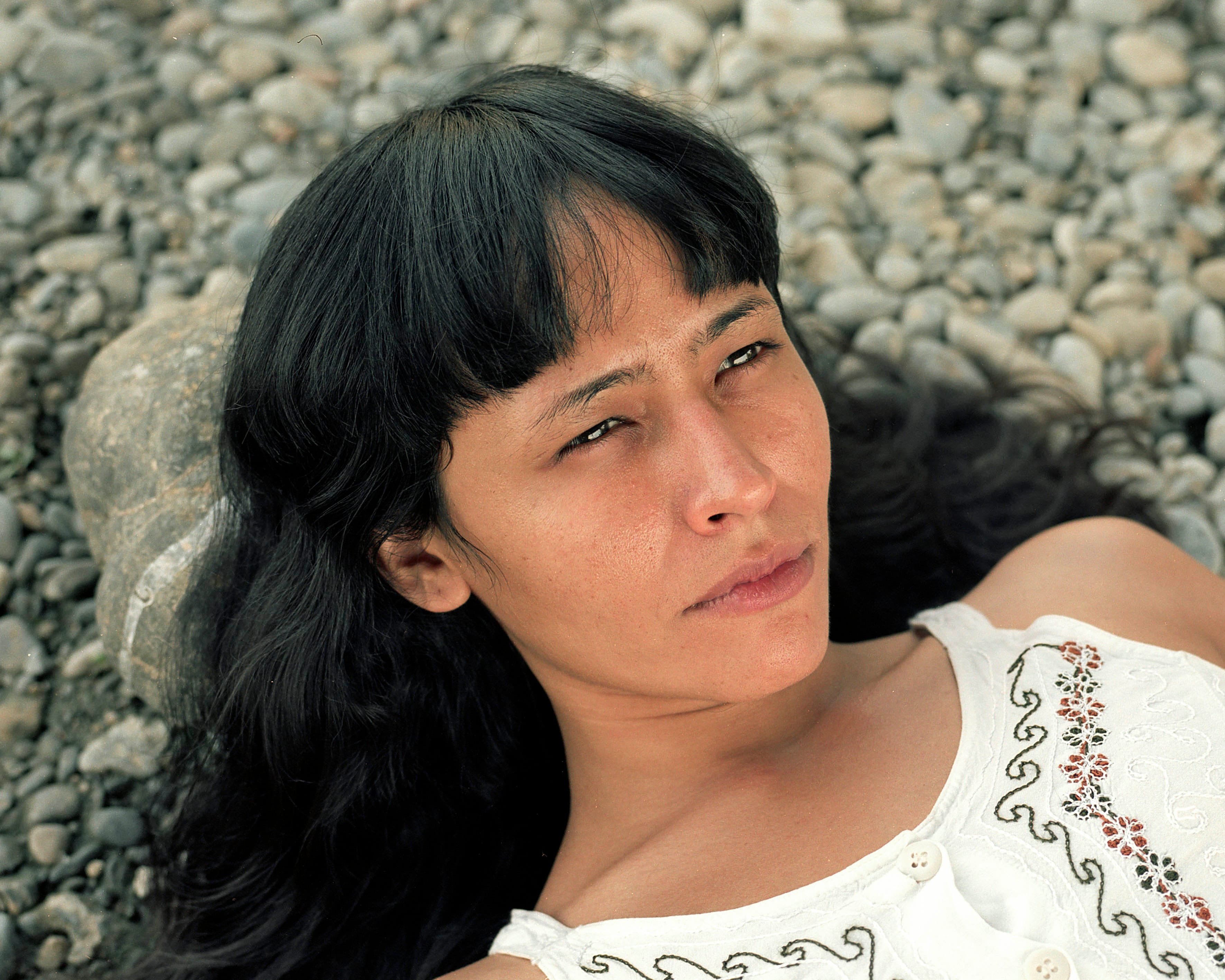 Woman looking serious into the sky on a beach