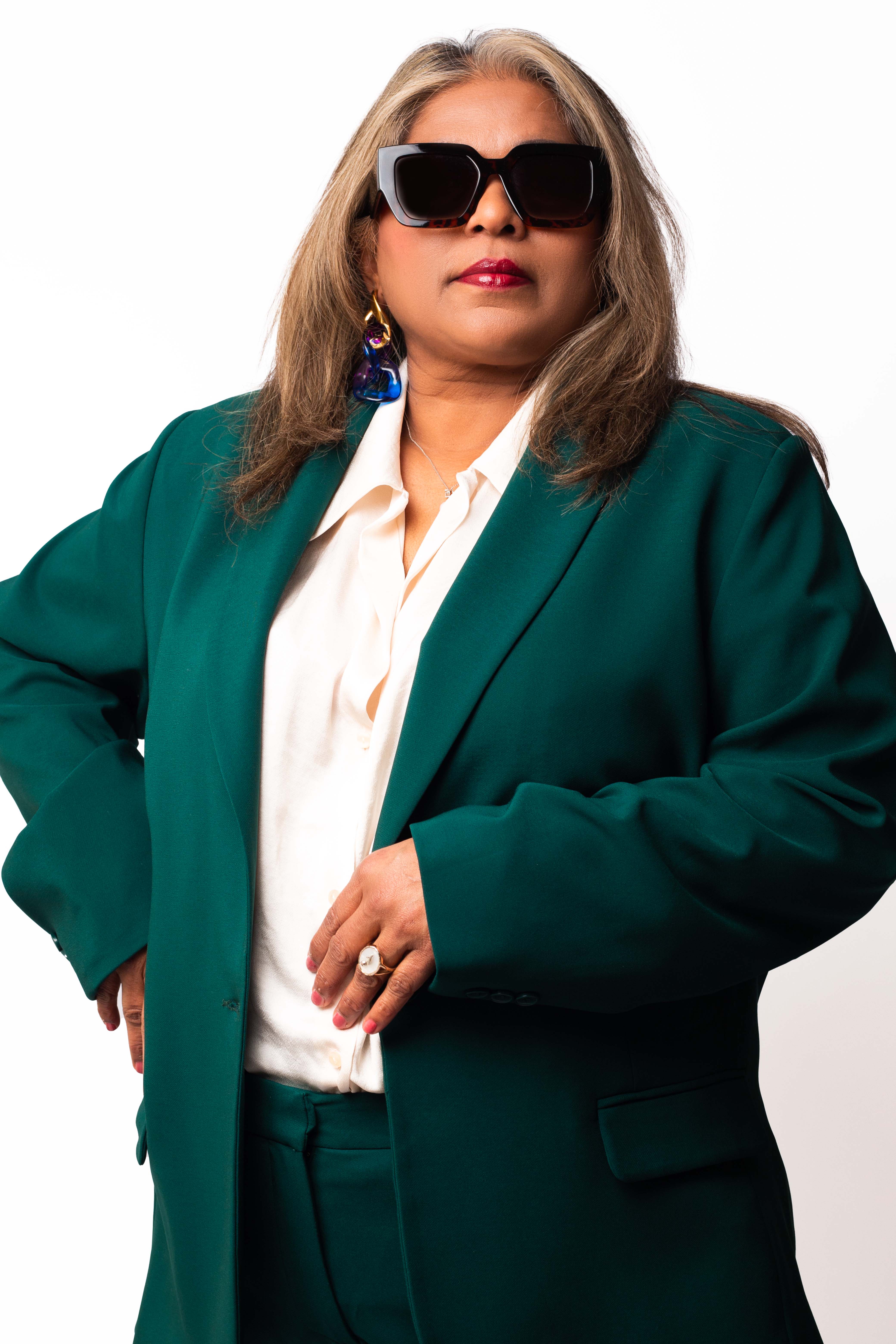 Portrait of the photographer's mother wearing a green jacket and sunglasses. © Kyara Bhiekharie