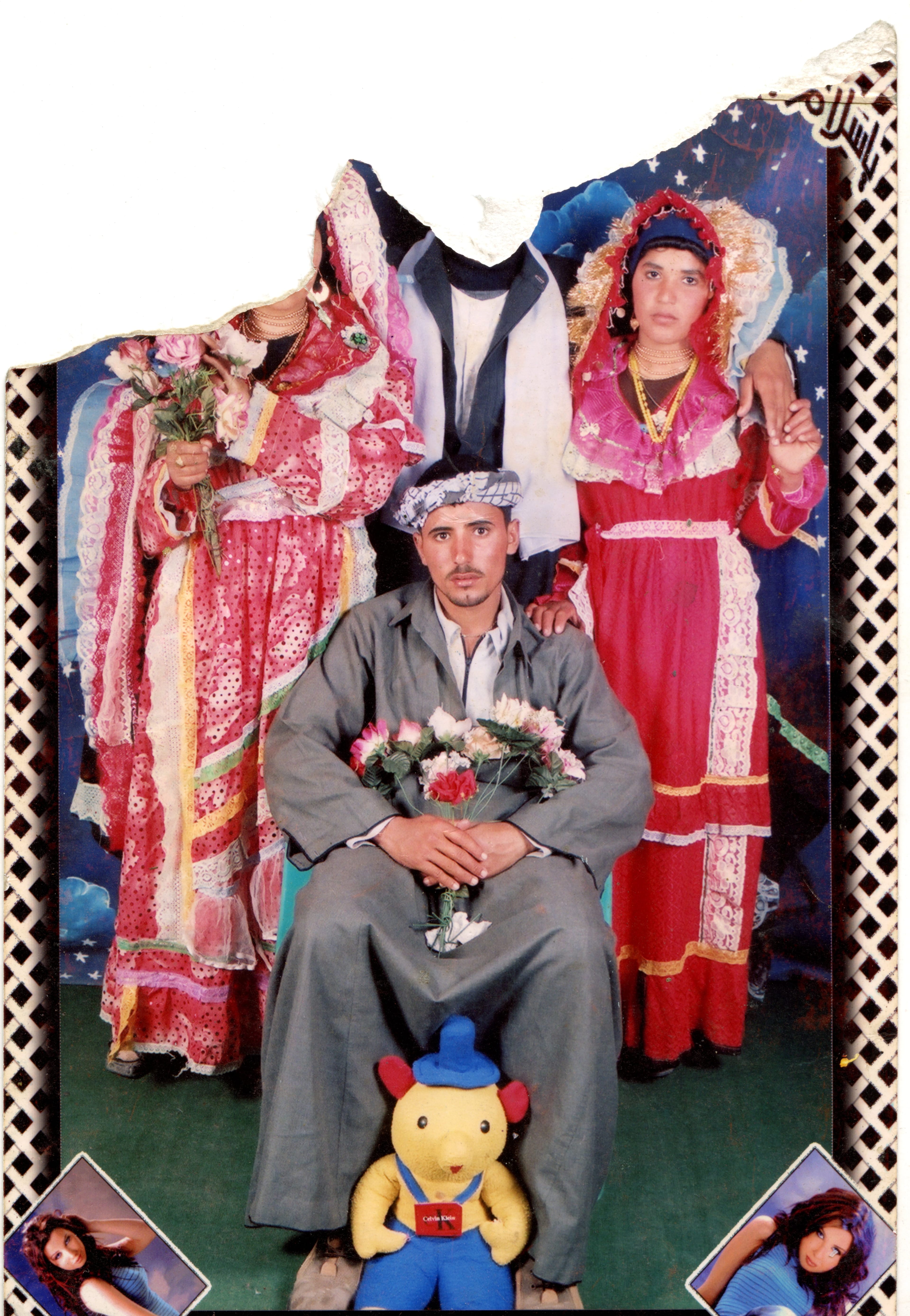 Group photo with individuals in colorful traditional attire, one seated holding flowers, surrounded by two standing figures with floral hats.