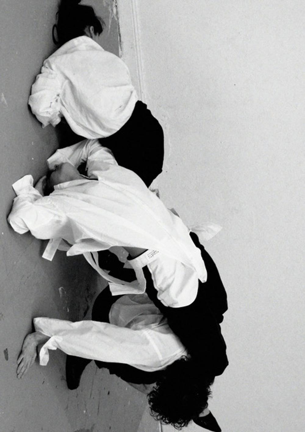 Black and white image of three people tumbling on top of each other