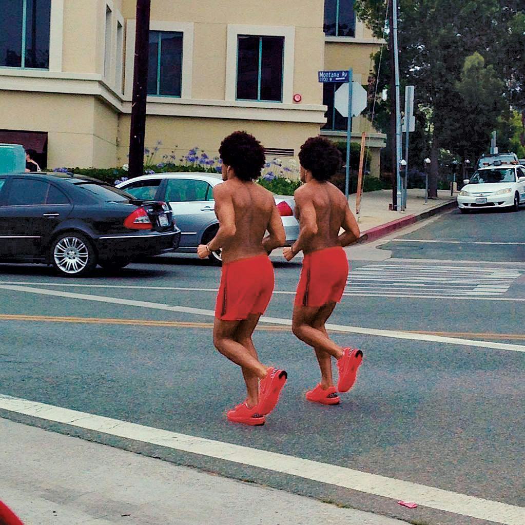 Two identically looking men running in the street