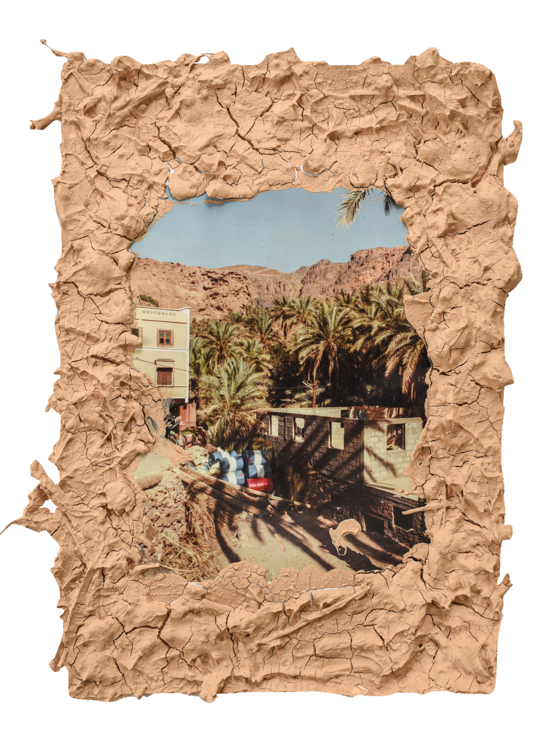 Image framed by soil, showing buildings in an Moroccon oasis.