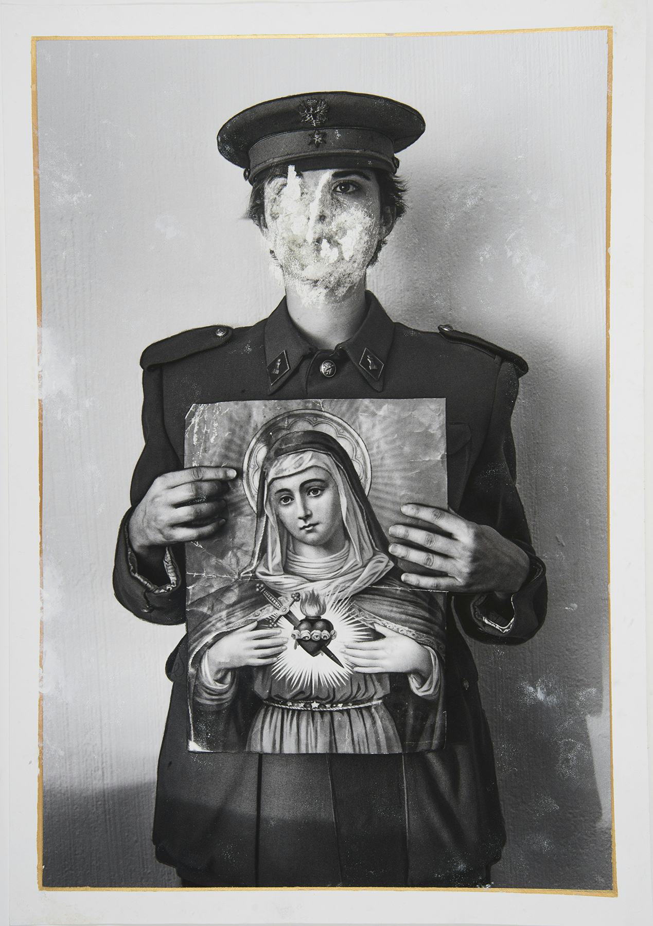 Black and white photo of an unknown soldier dressed in post-Civil War uniform holding a virgin portrait. © Lucia Higuera