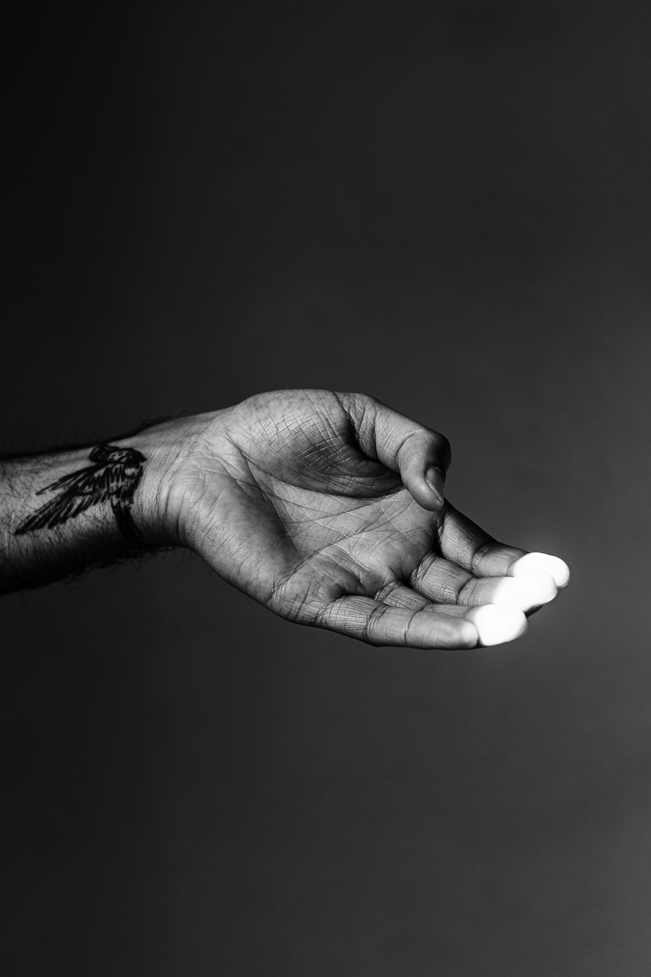Black and white photo of Marvel Harris' hand, the tip of his fingers touched by light. © Marvel Harris