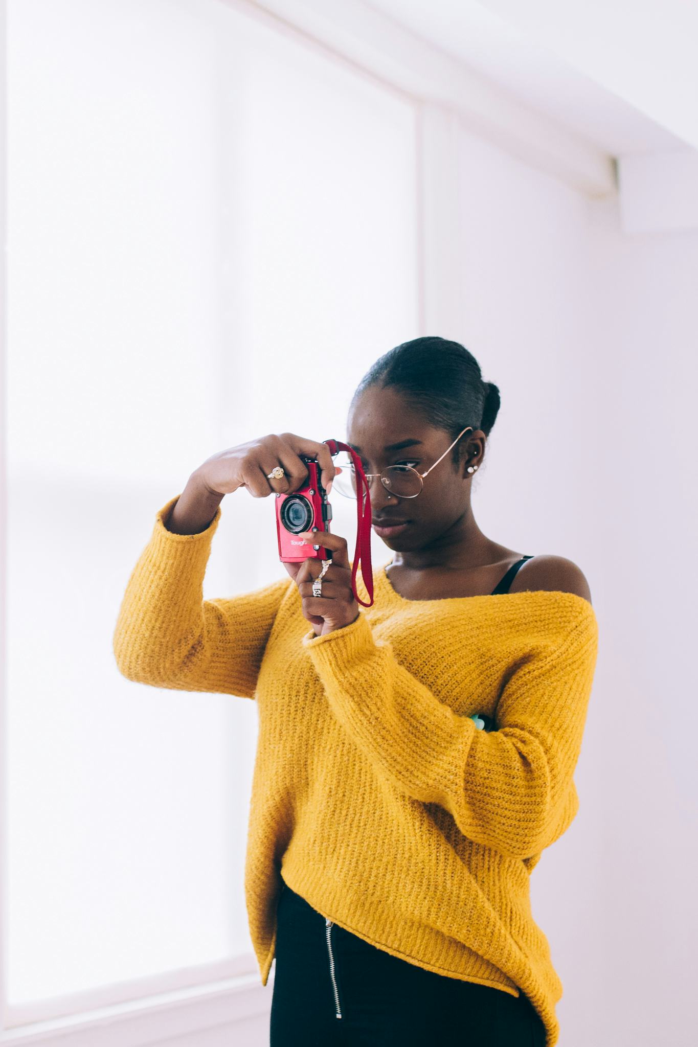 Photo of a girl in a yellow sweater taking a picture