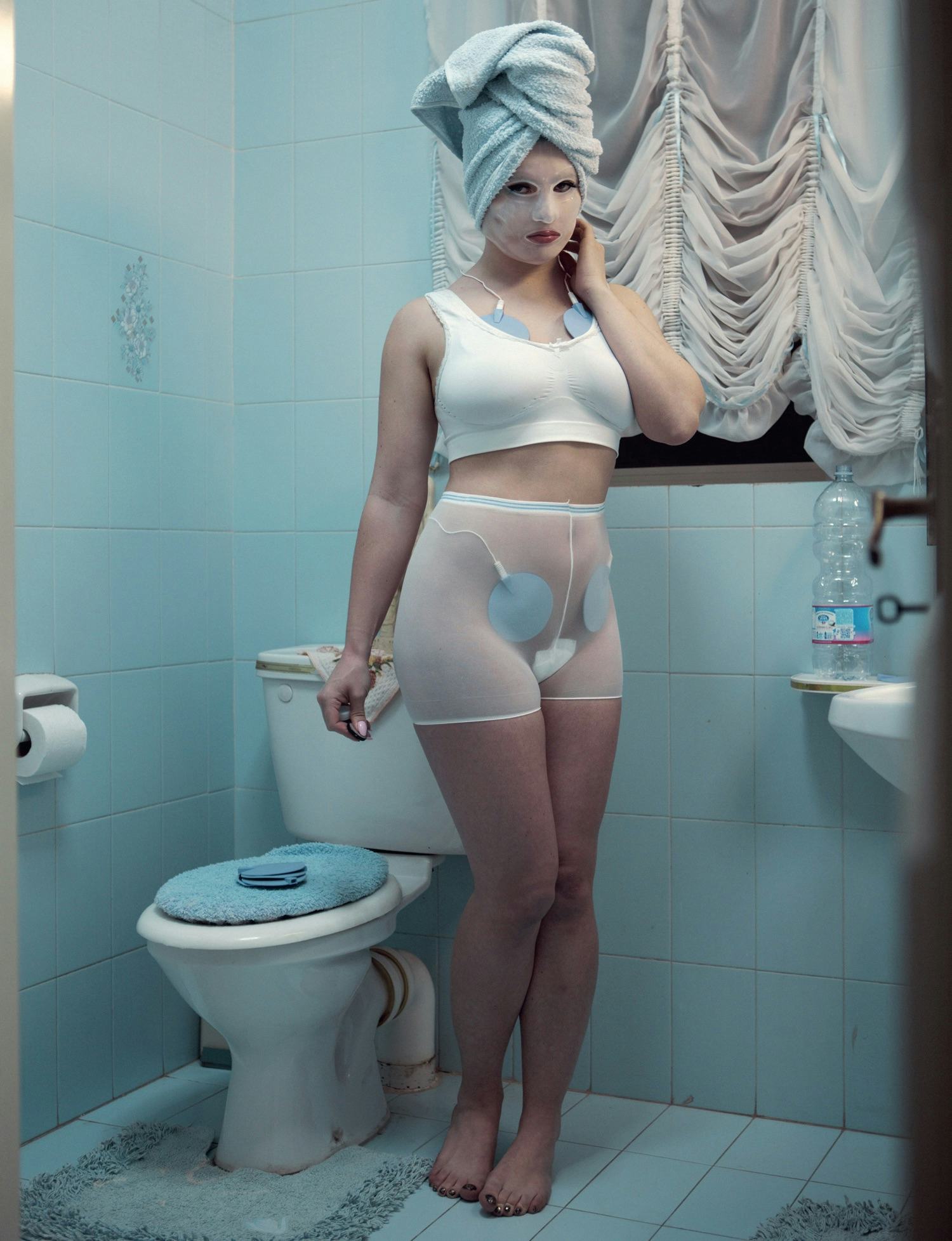 Page 212 from Foam Magazine #45: Talent - showing a self-portrait in a blue bathroom by Juno Calypso