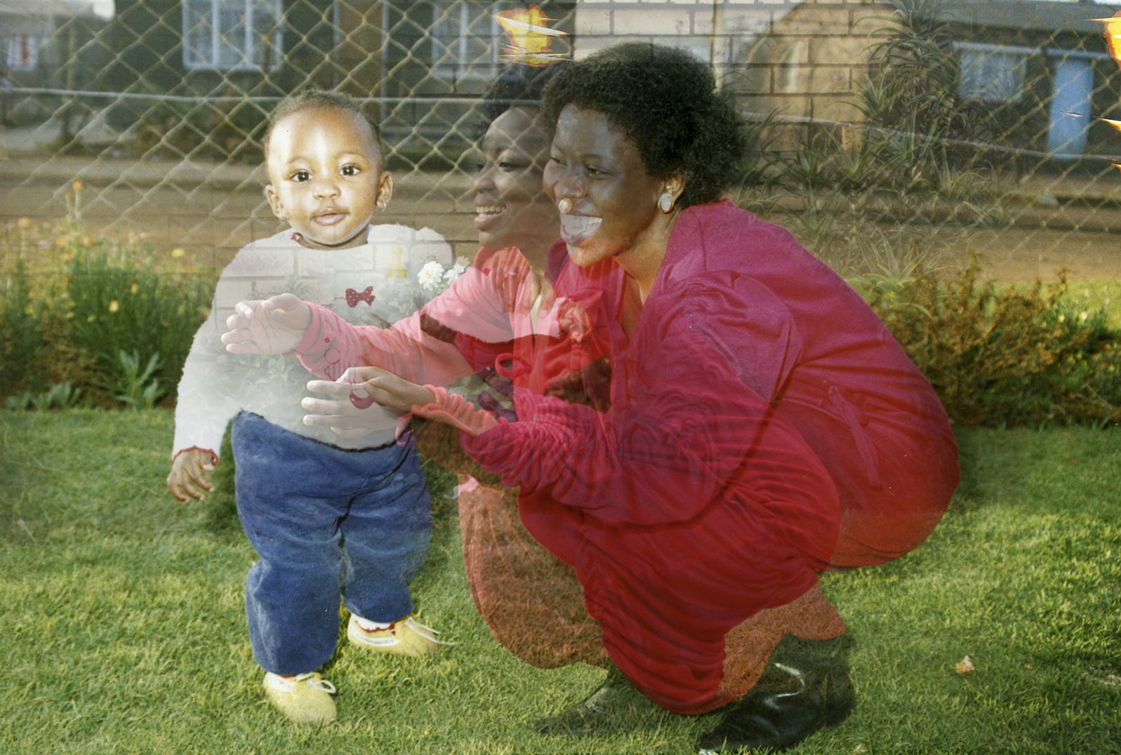 woman in red dress with baby on grass