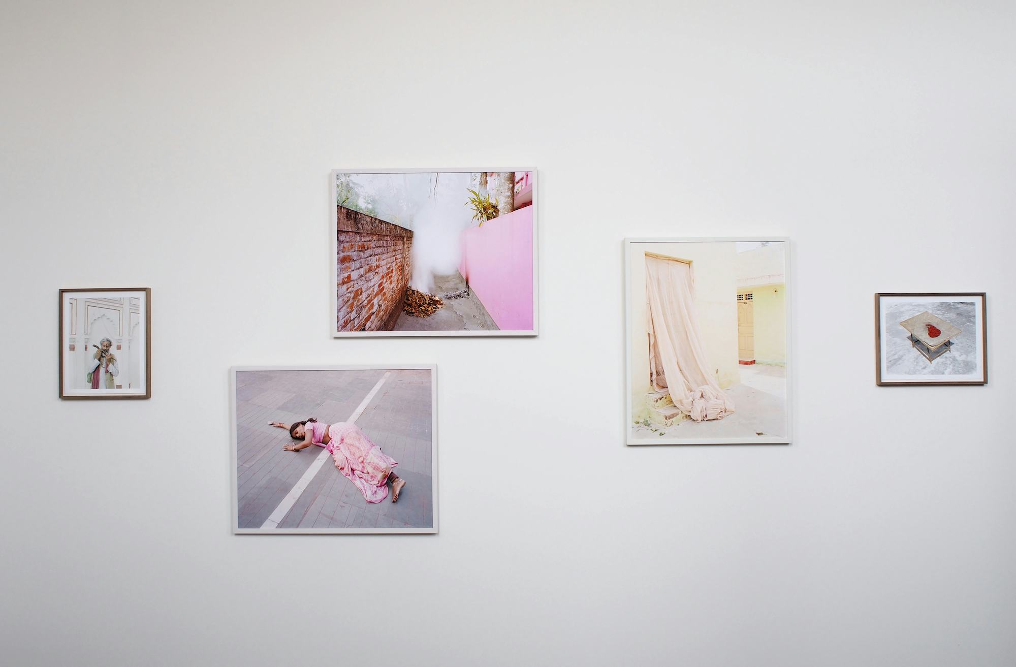 5 framed colour photographs by Vasantha Yogananthan hanging on a white wall