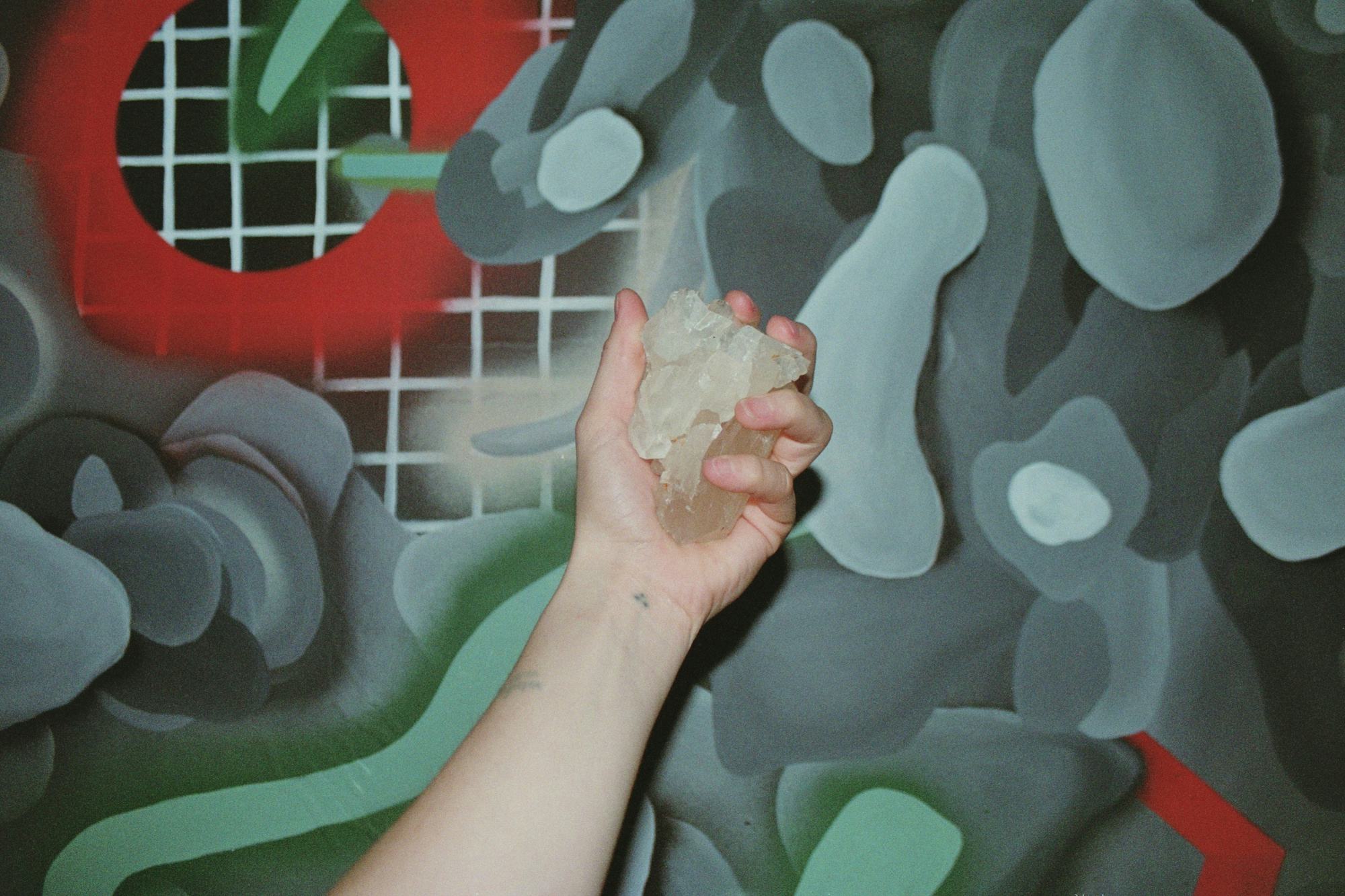 Collage of a hand holding a rock on top of an abstract background. ©Kıvılcım S Güngörün