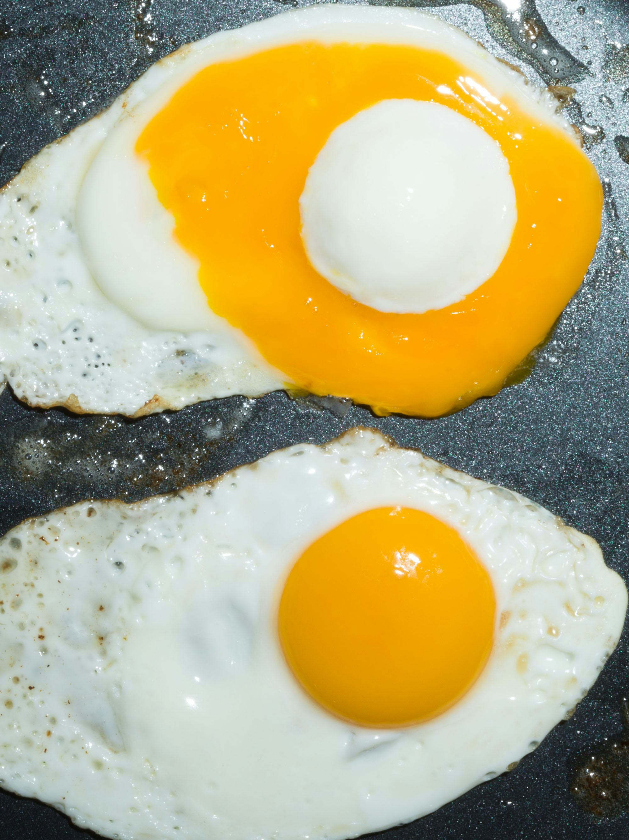 Close-up image of two eggs, with inverted yellow and white yolk © Andrea Orejarena & Caleb Stein