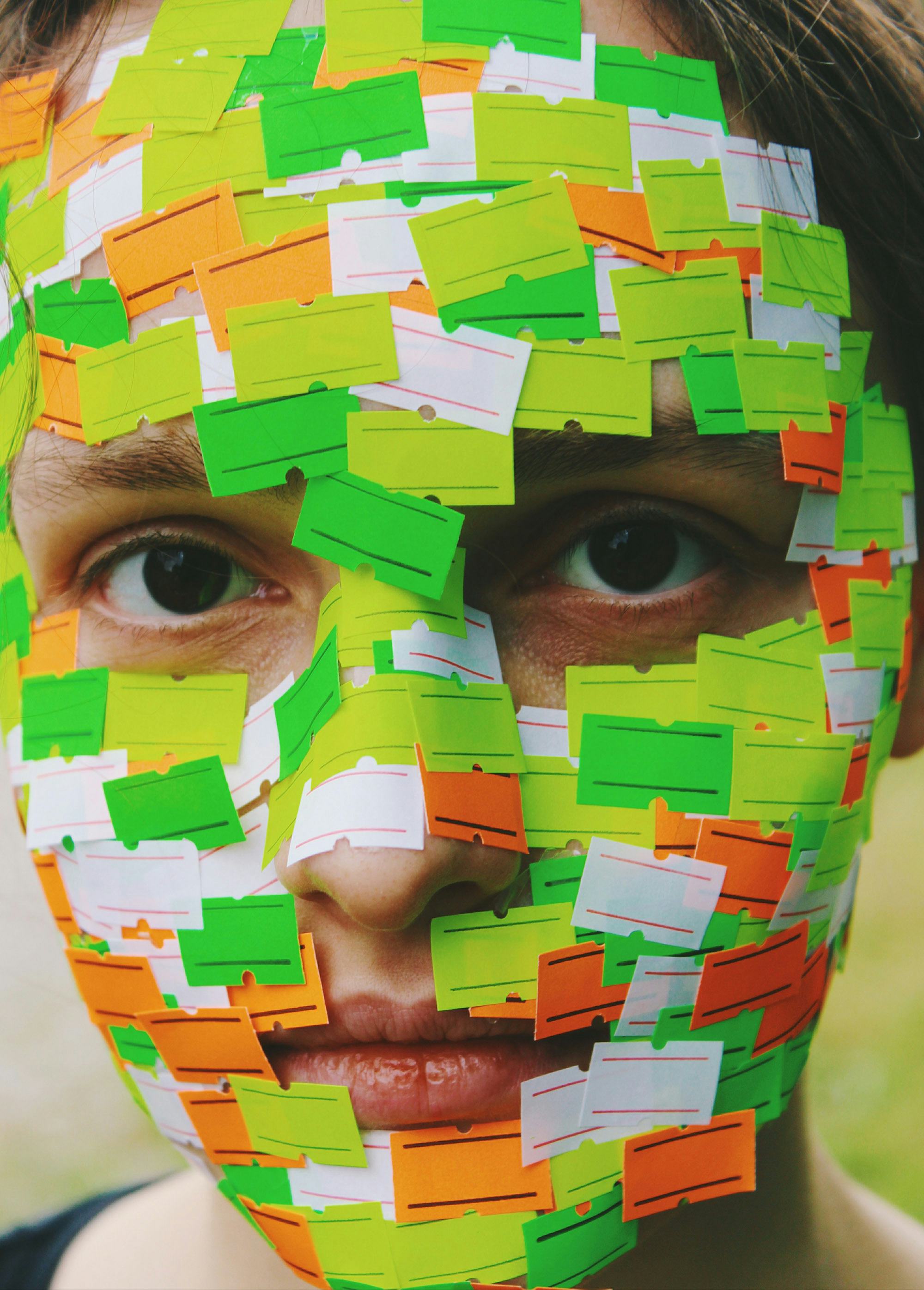 Portrait of a woman whose face is covered with empty price stickers. © Alp Peker