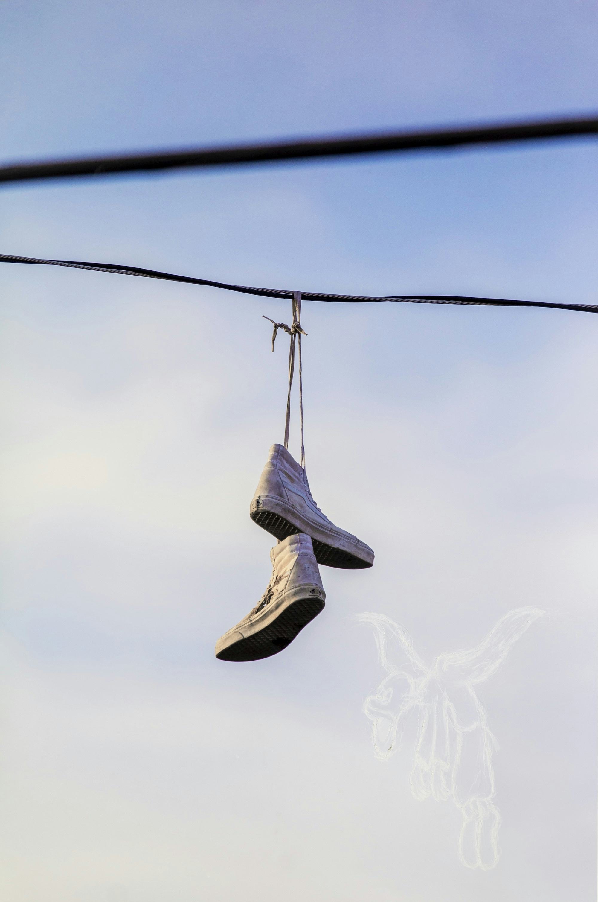 Picture of a pair of shoes hanging from a cord in the sky © André Ramos-Woodard