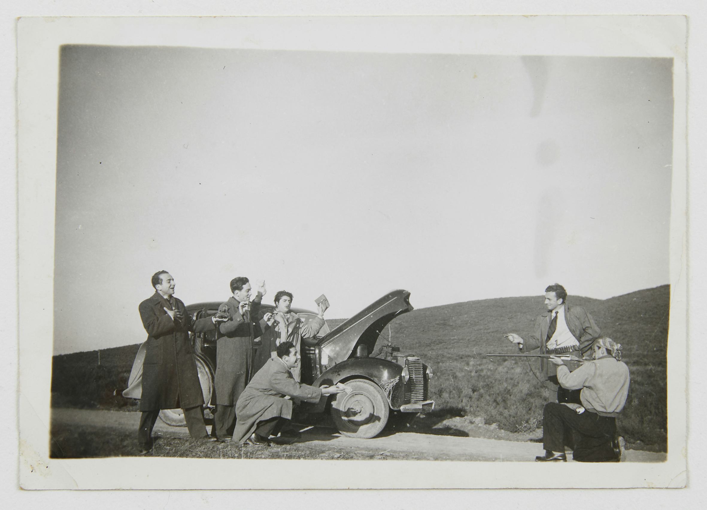 image of men standing around a car