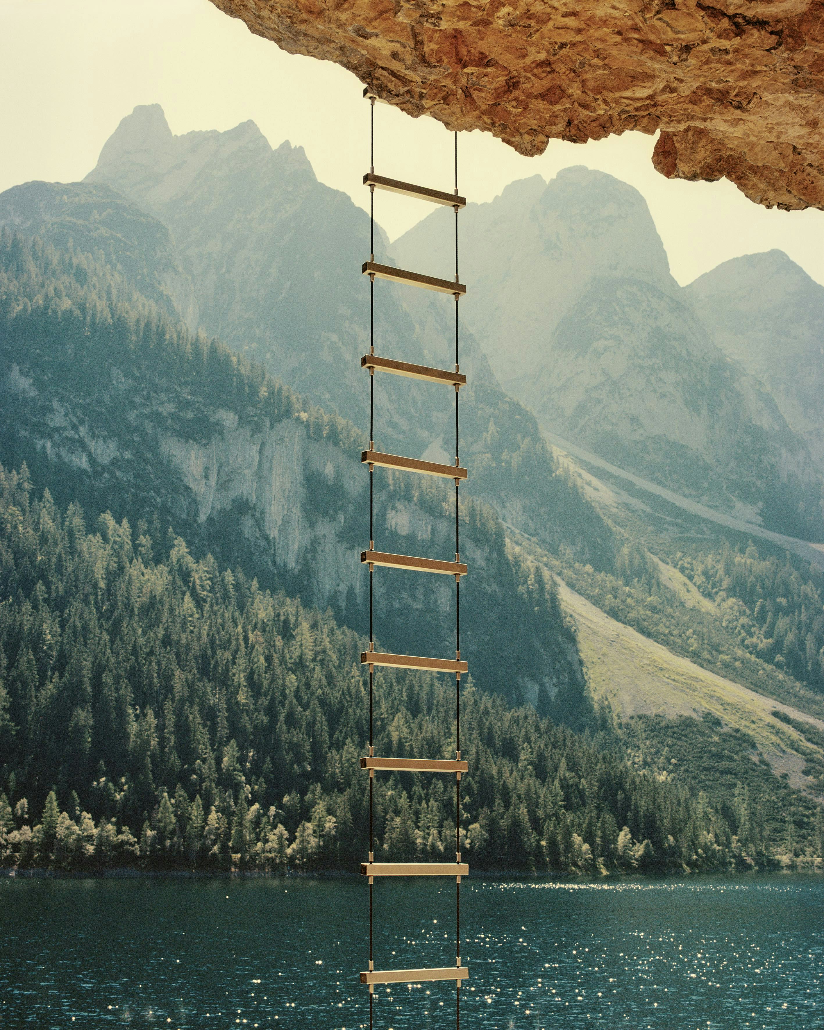 Picturesque image of mountain landscape with a mountain lake and in the forefront a ladder hanging from a rock