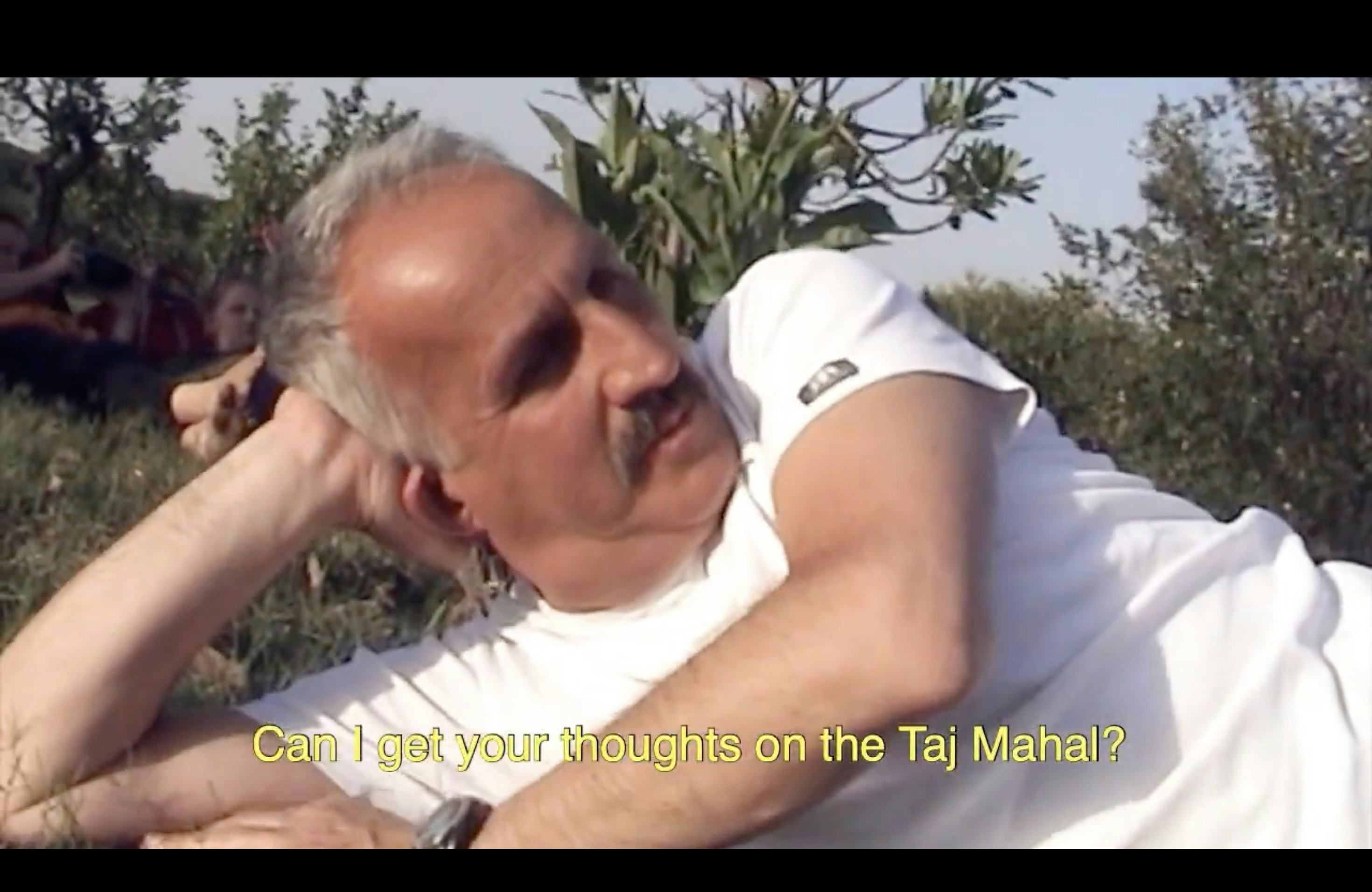 Screenshot from video showing Hüseyin lying on the grass near Taj Mahal, India. From the project Dad on his search for Hüseyin by Olgaç Bozalp
