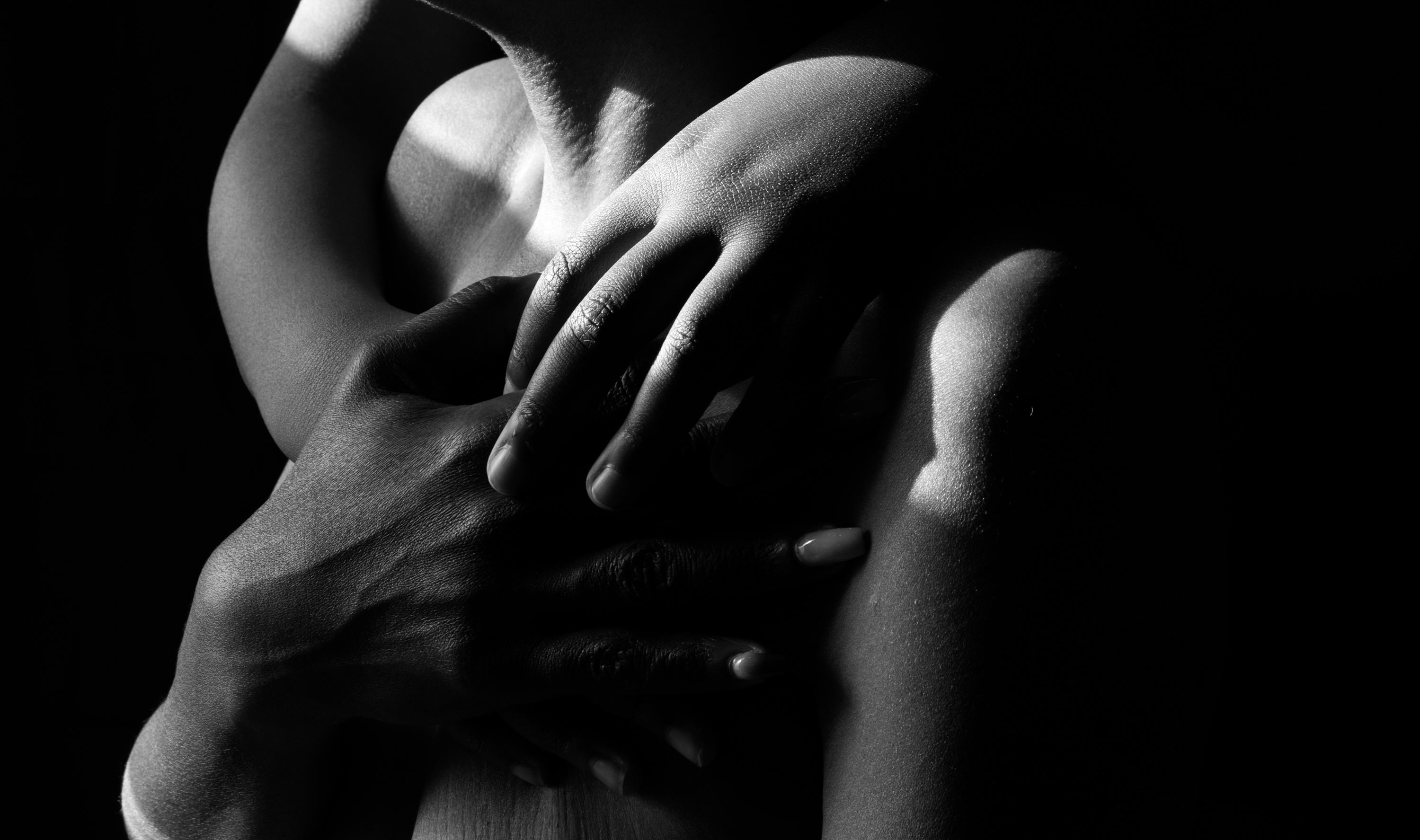 Black and white image of several hands over a topless chest. © Iyanla Etnel
