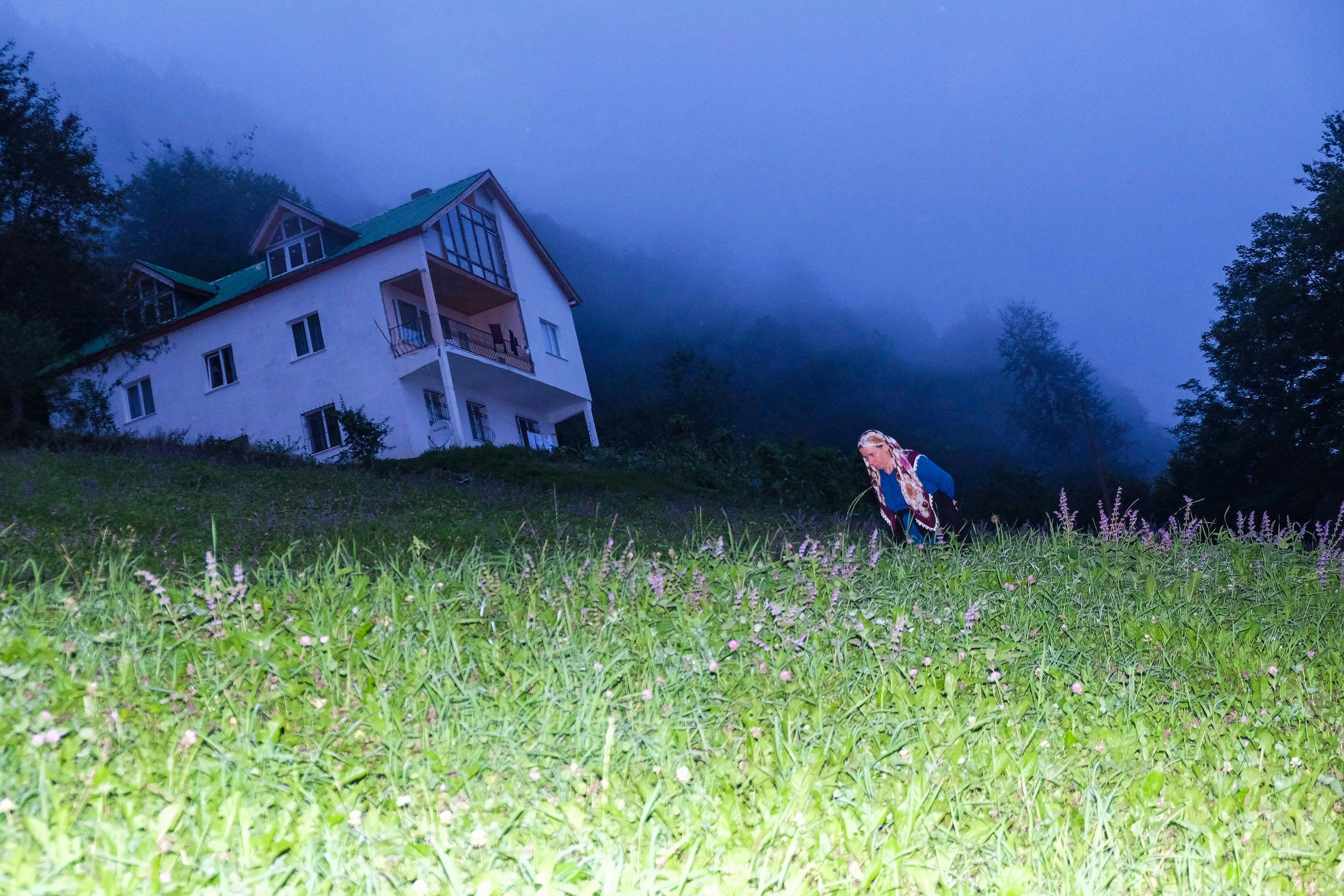Image of a woman walking through a field in the Kushmer Highlands at night. © Cansu Yıldıran