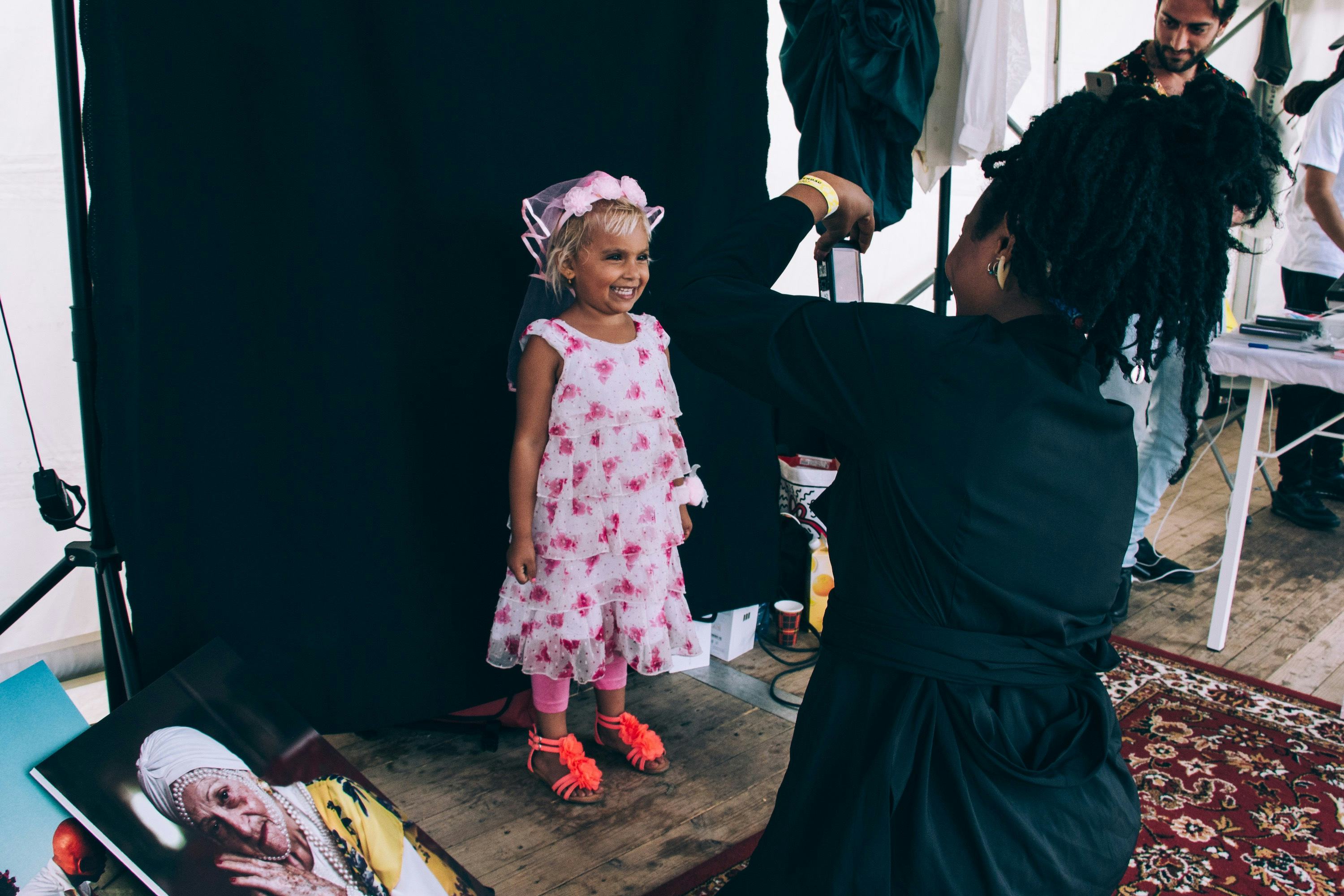 Photo of a young girl in a pink dressing getting her portrait taken.