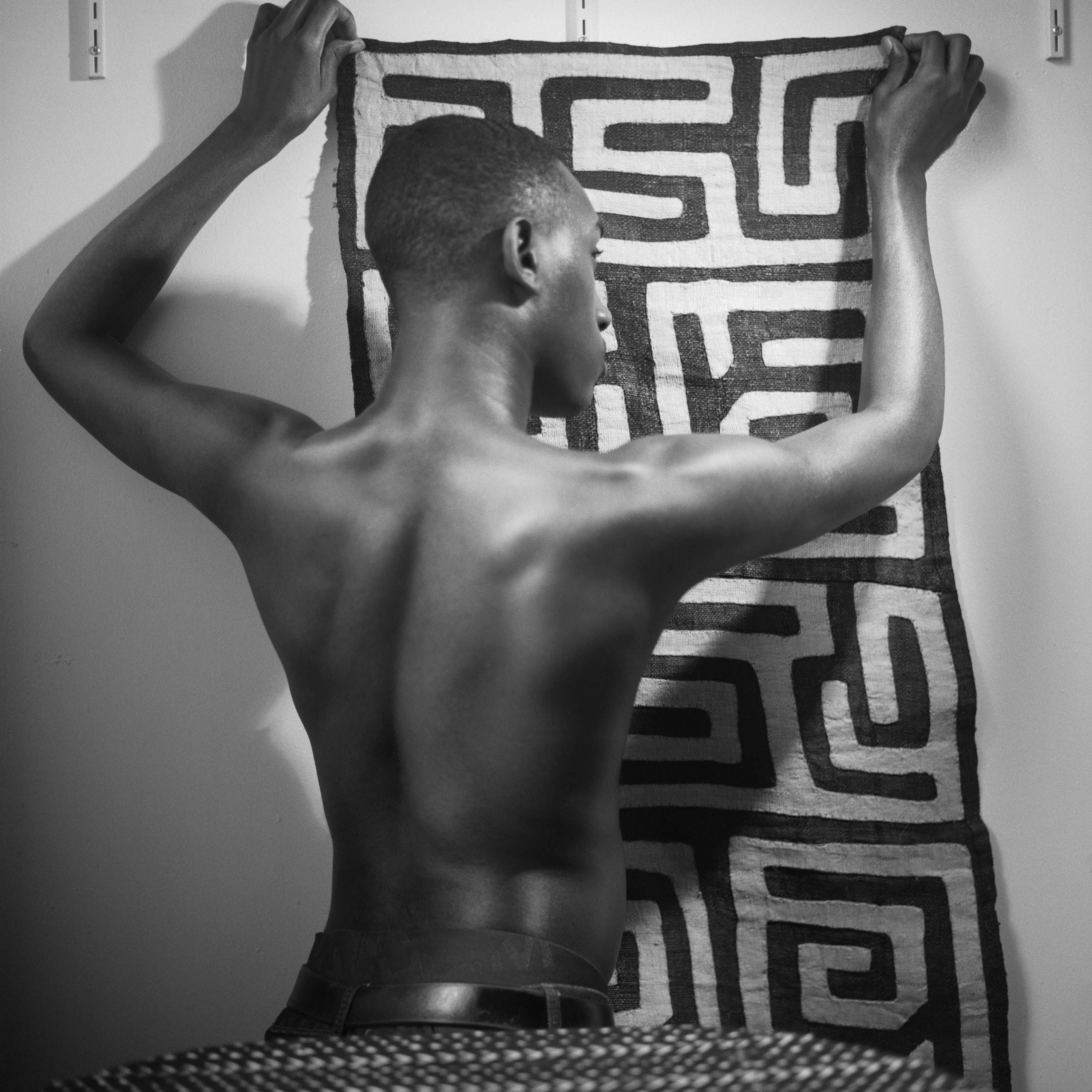 Young man holding up Kuba cloth 2019 C John Edmonds
