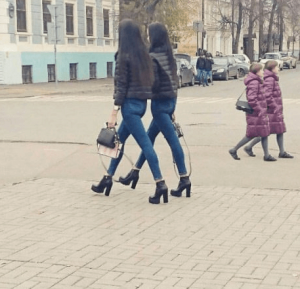 Picture of two pairs of identically dressed and appearing people, walking on the street