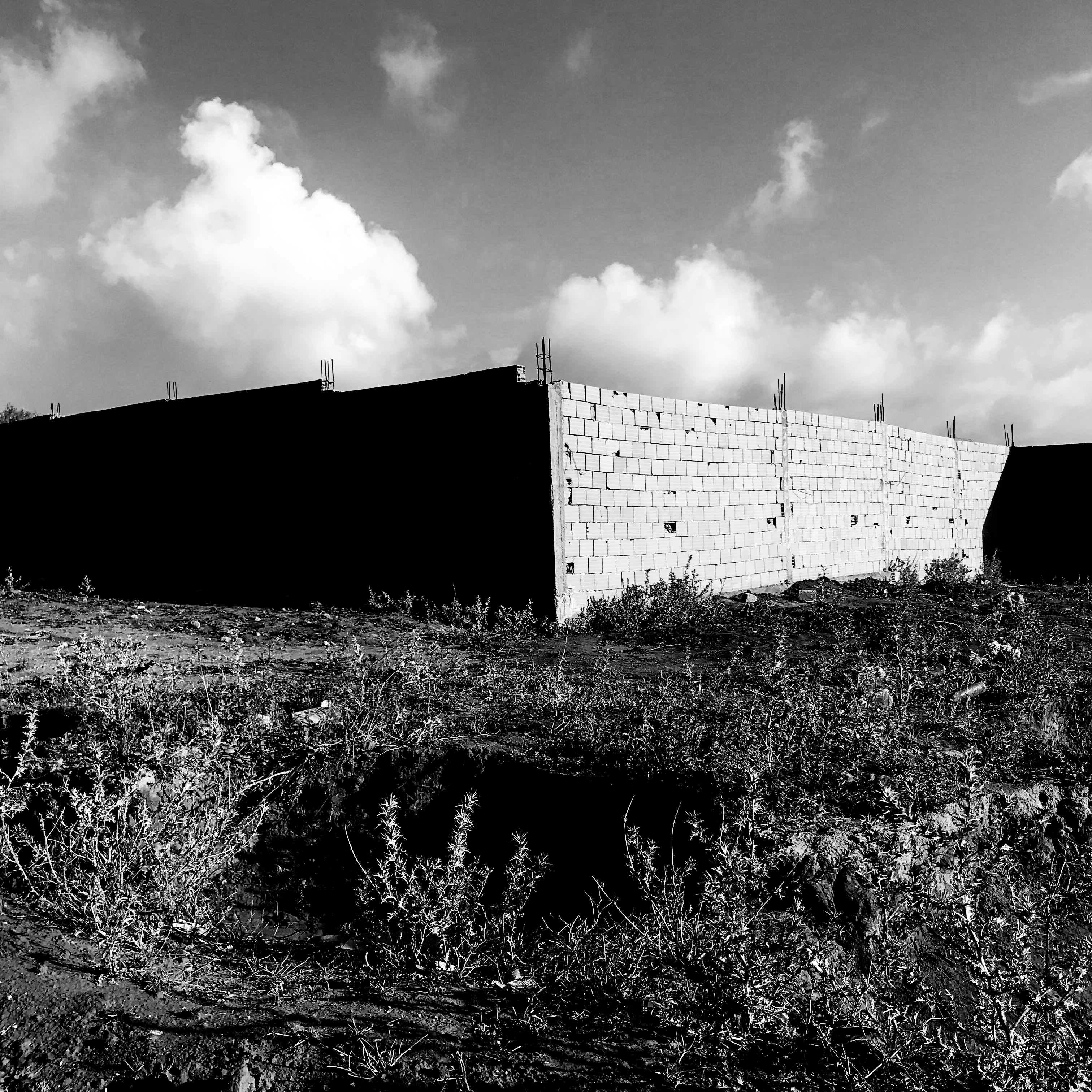 Black and white image of a brick building under construction. © Issam Larkat