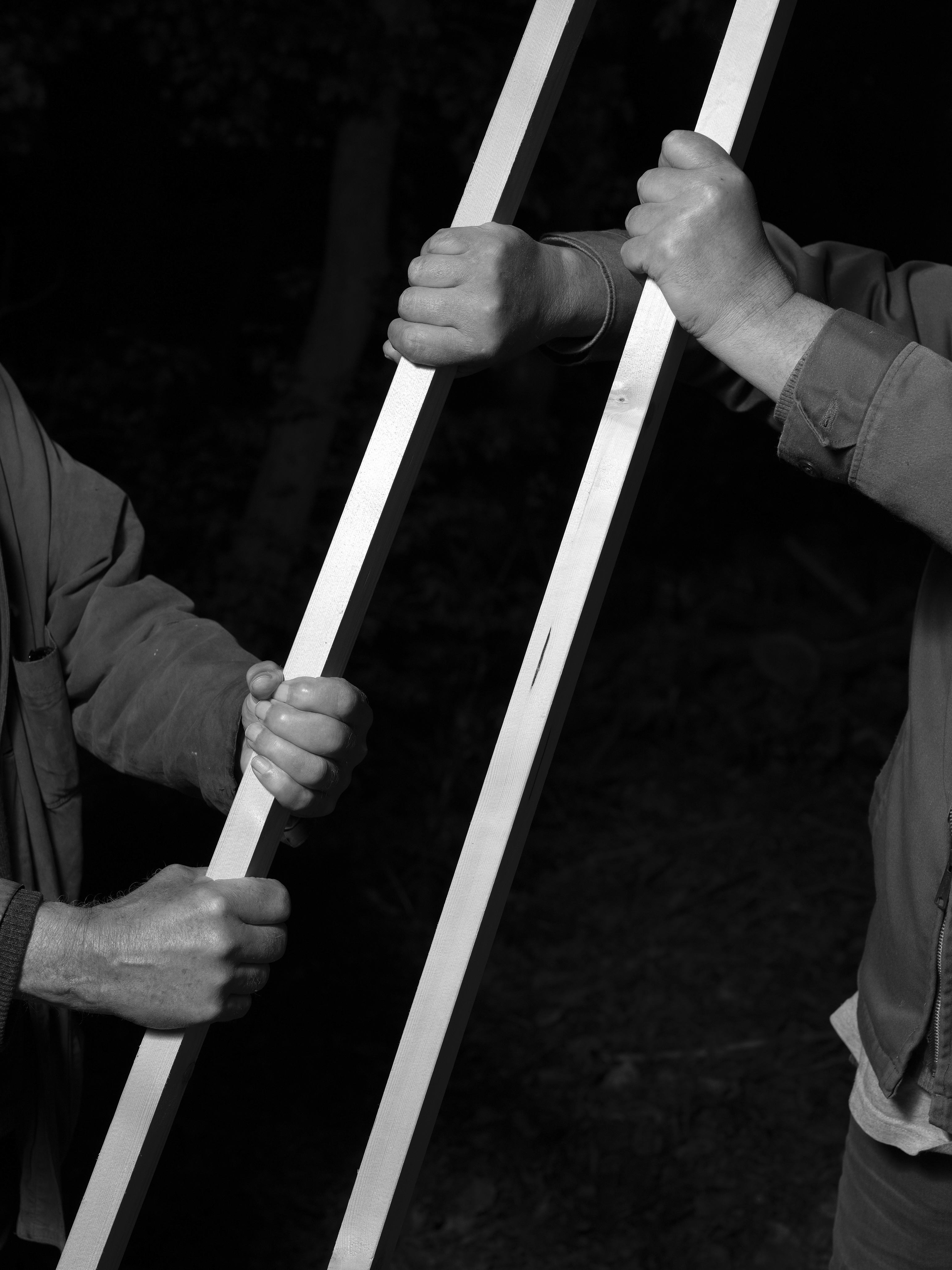 two people holding two rods in black and white