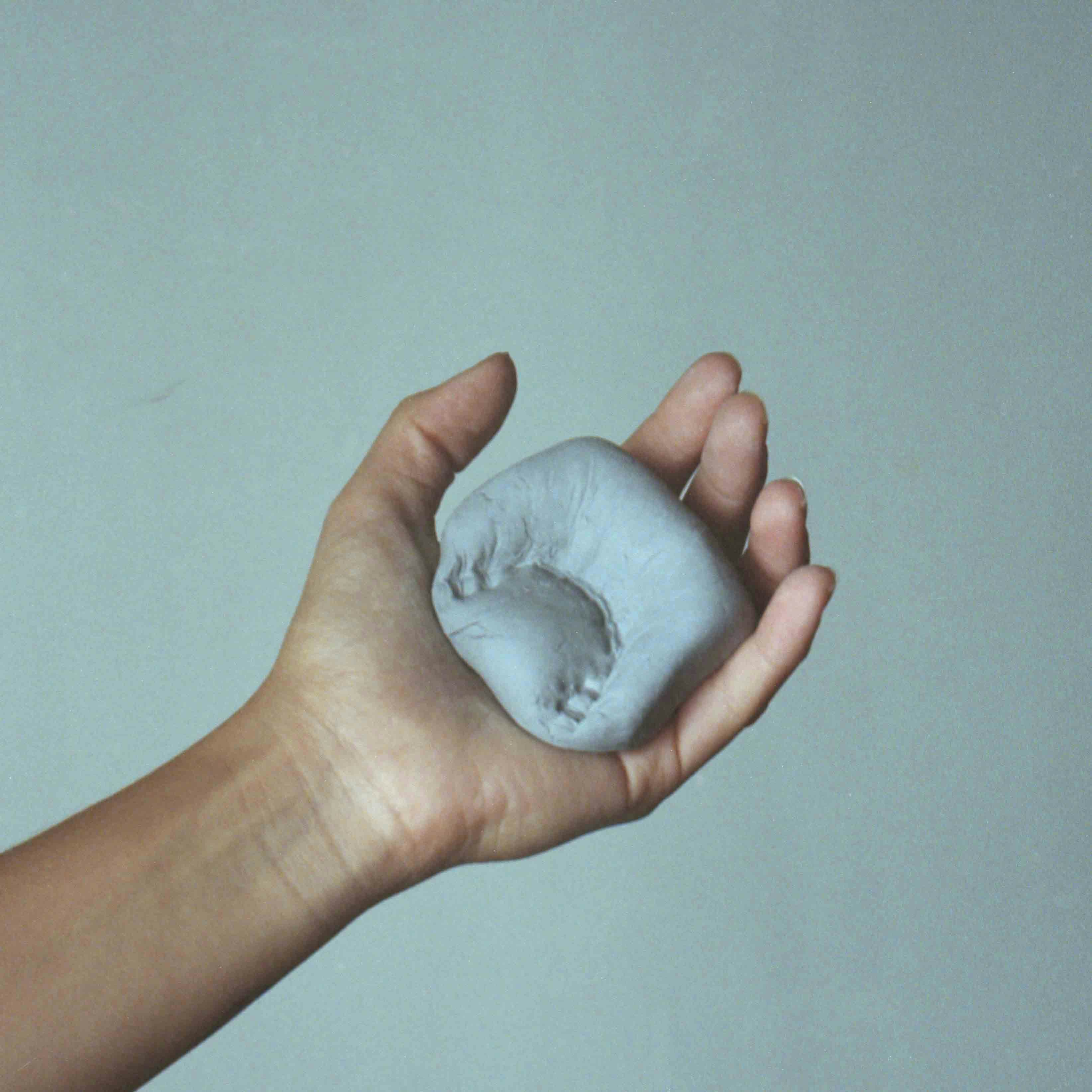 Image of a hand showing a denture with an imprint of teeth © MAryam Touzani