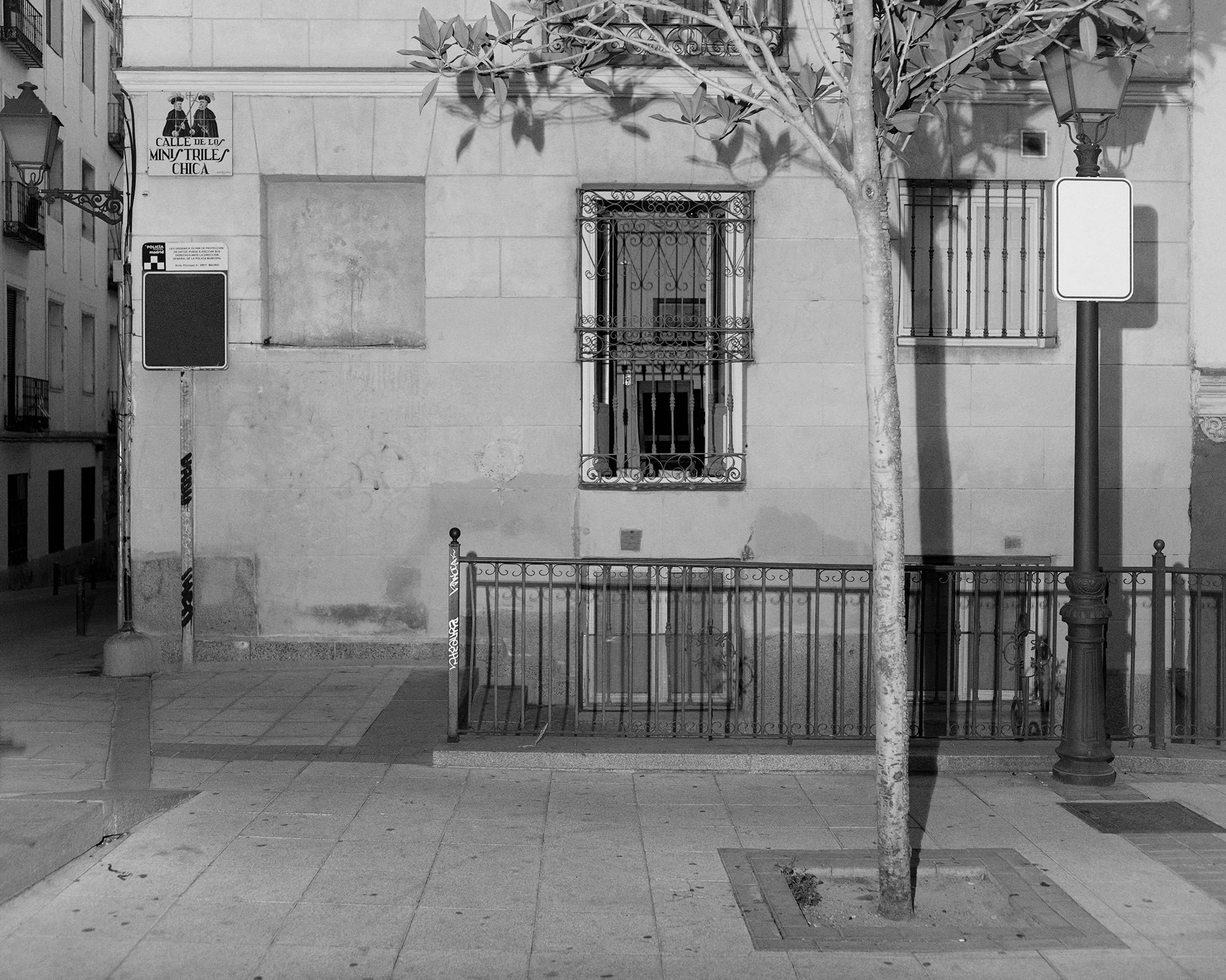 Black and white image of a Spanish looking street. No people are visible.