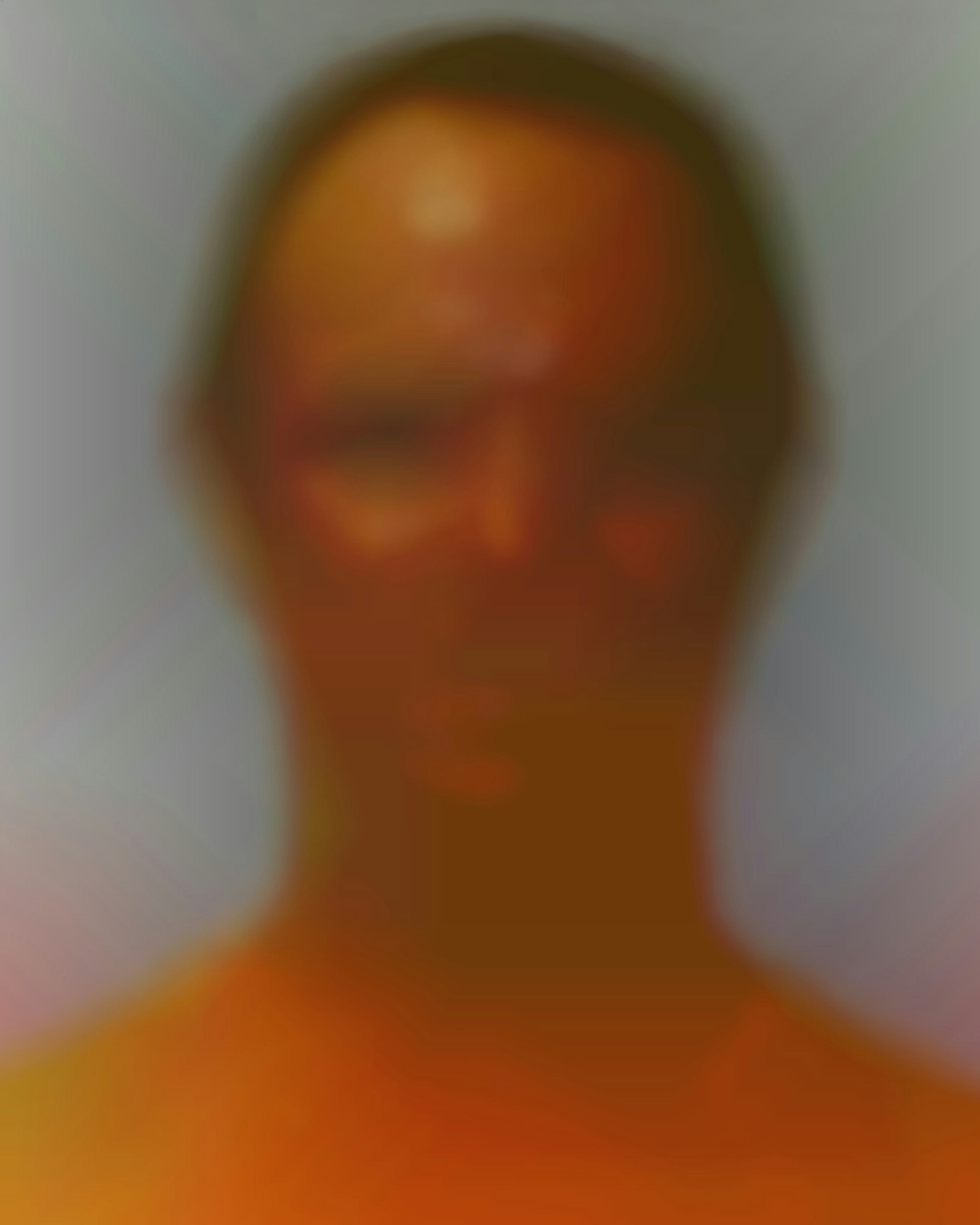Blurry portrait of a male-presenting figure, with warm coloured tones