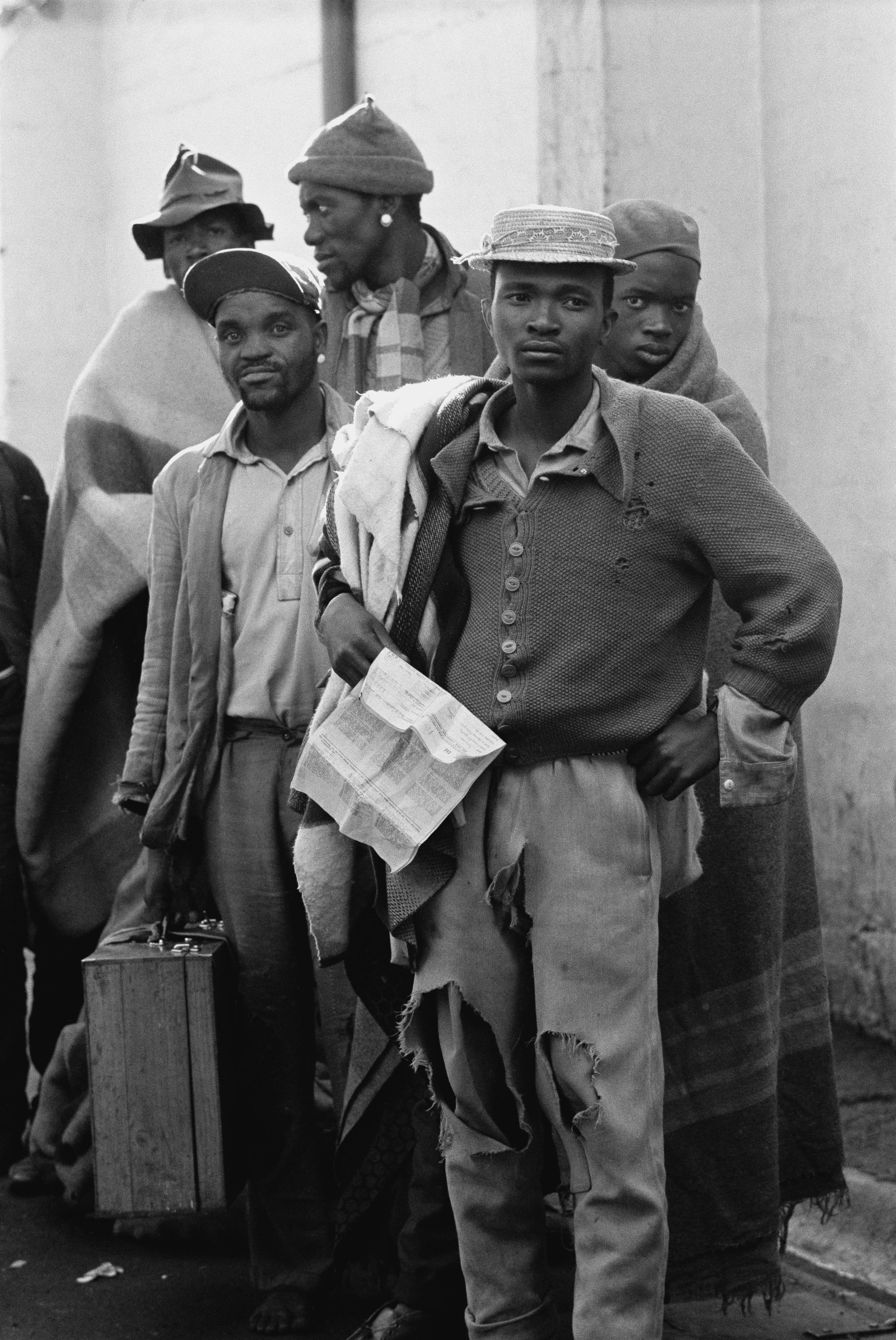 group of men with hats and suitcases