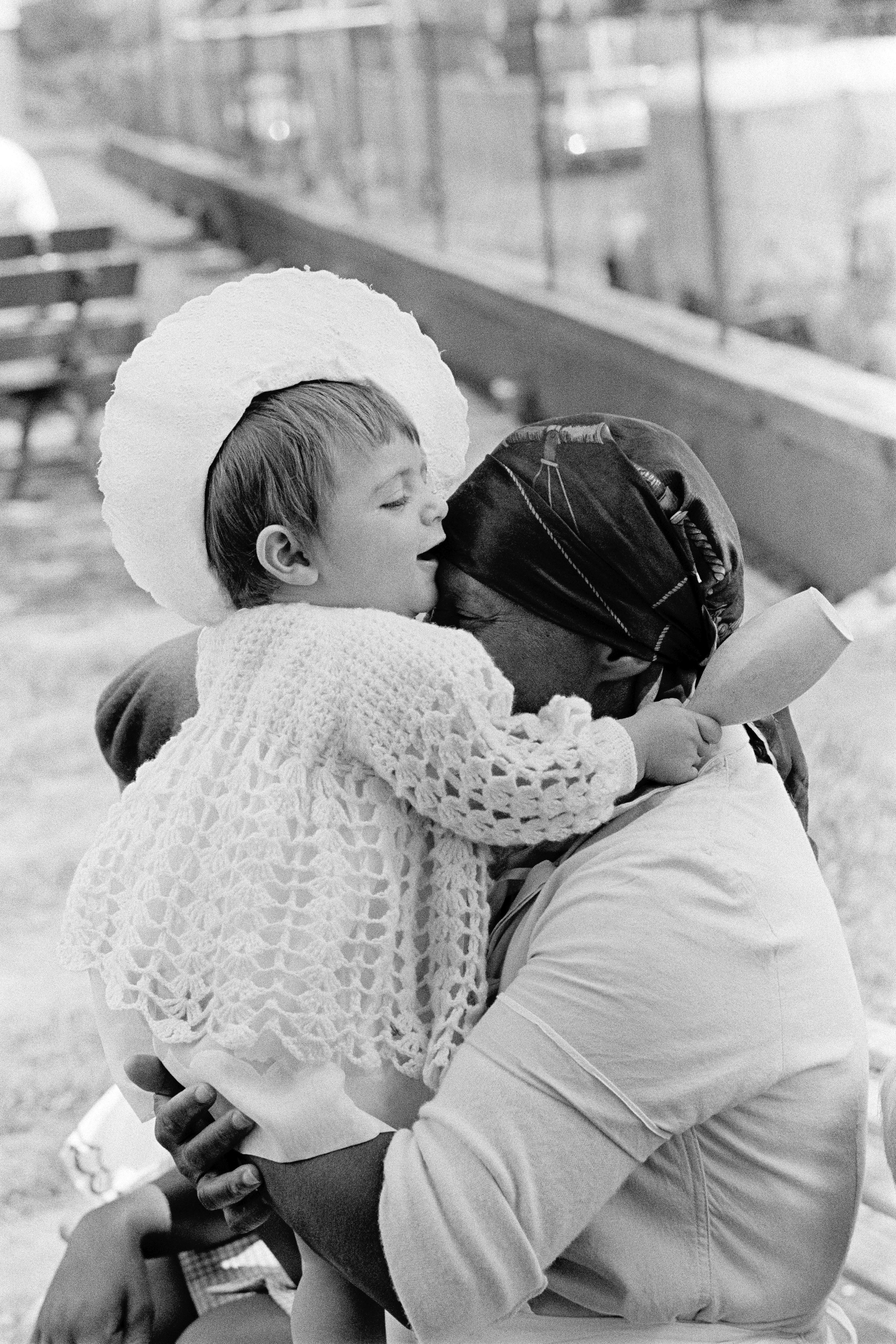 black woman holding white baby