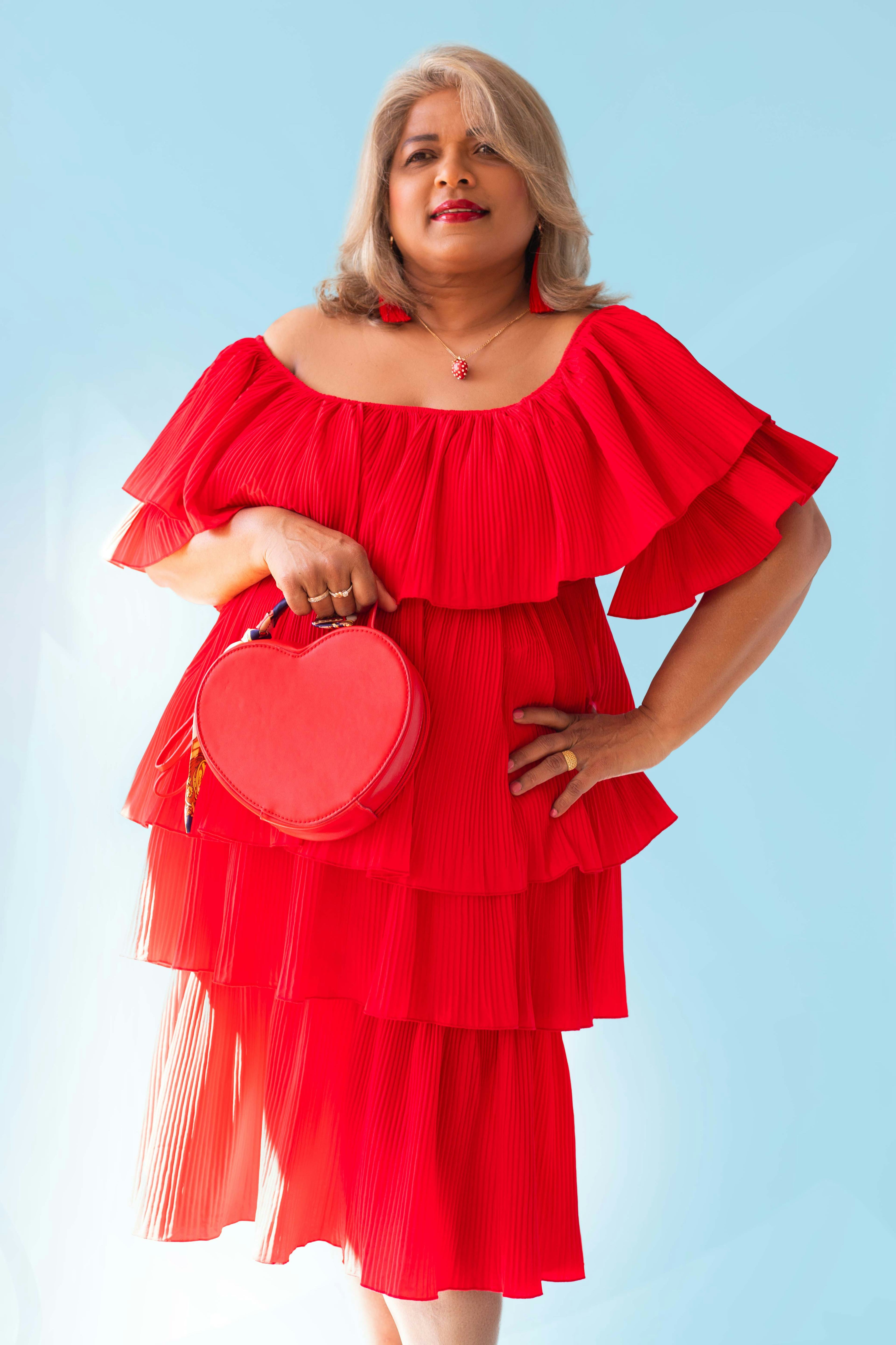 Portrait of the photographer's mother wearing a red dress. © Kyara Bhiekharie