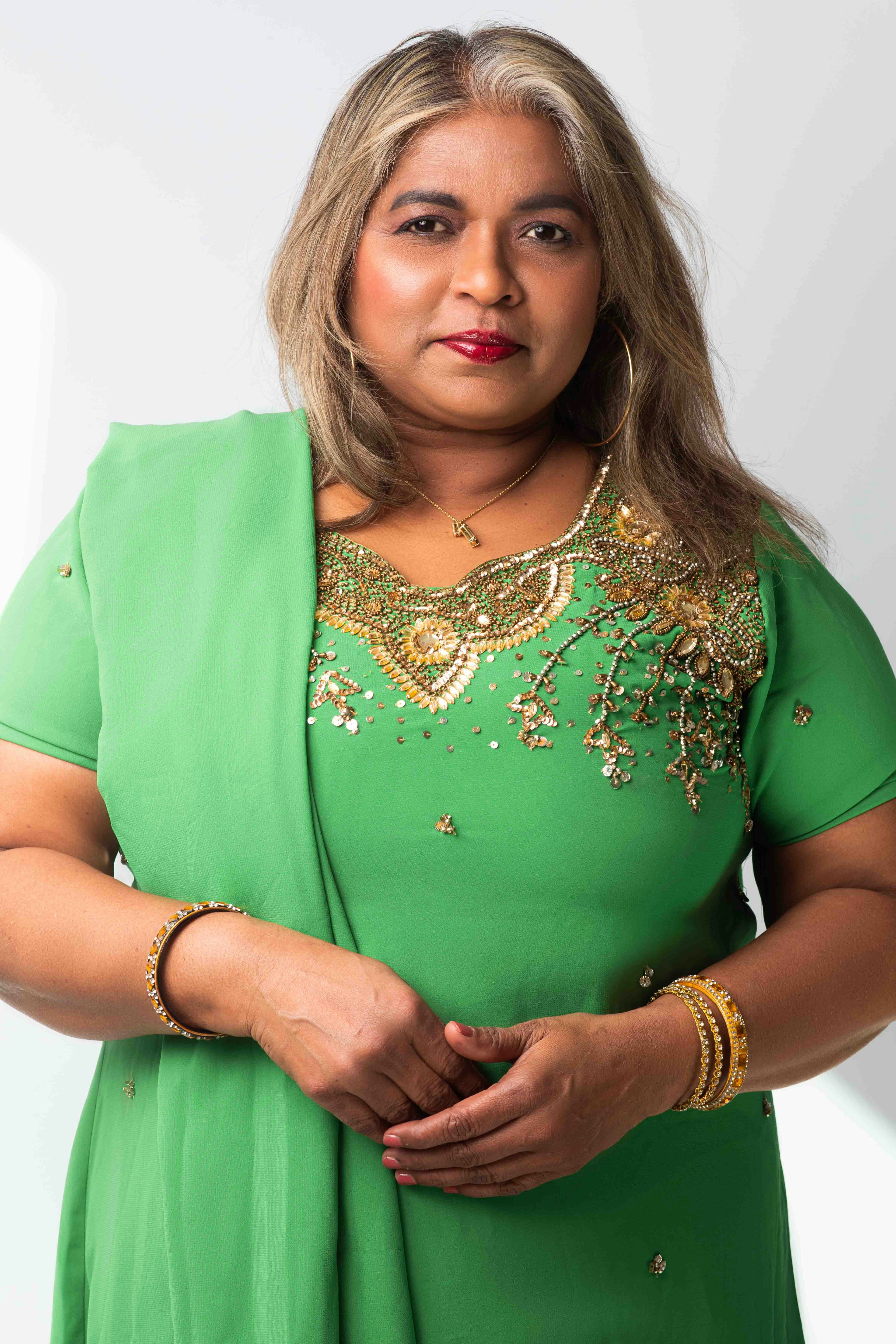Portrait of the photographer's mother wearing a green sari. © Kyara Bhiekharie
